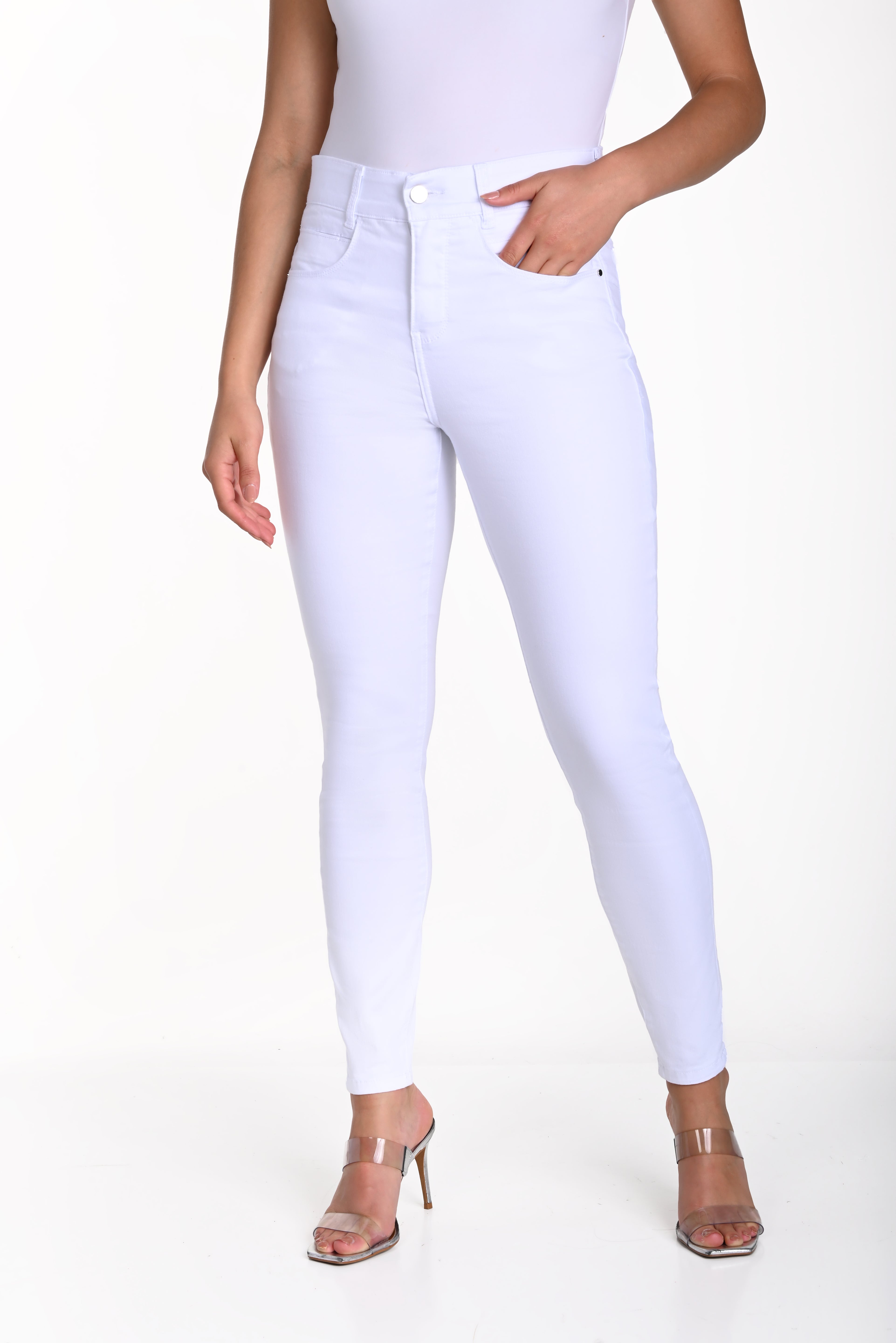 Woman wearing high-rise comfort stretch slim jeans in white, showcasing a stylish and comfortable fit.