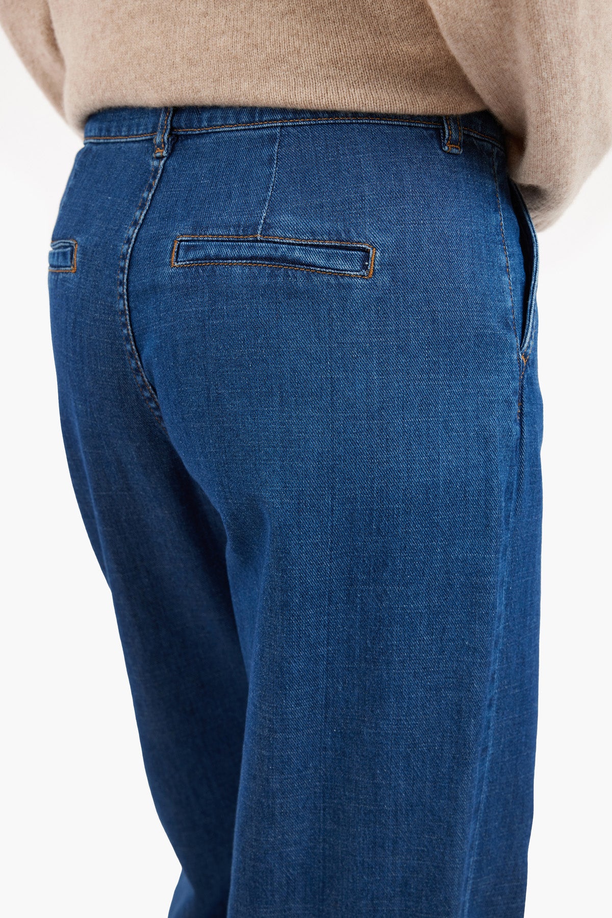 Back view of tapered barrel-leg jeans showing the denim texture and polished design.