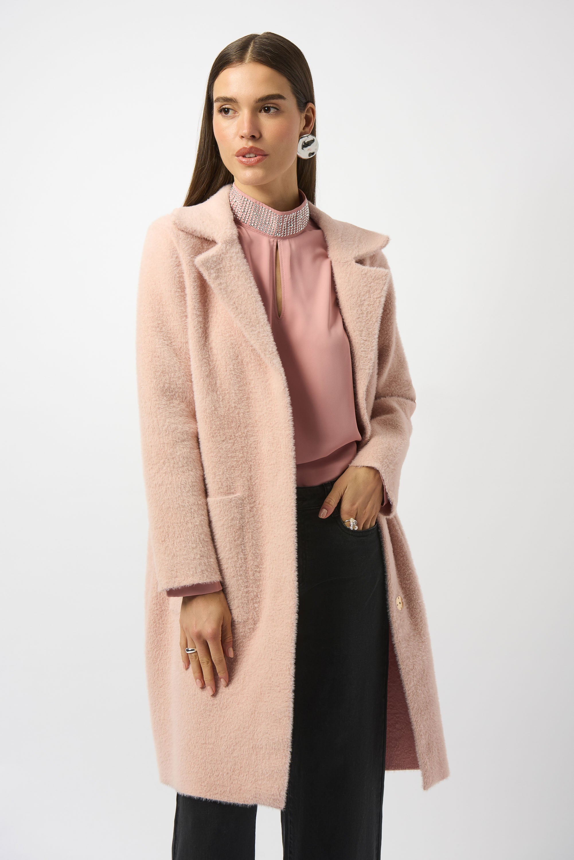 Woman wearing a pink coat over a pink shirt on a white background