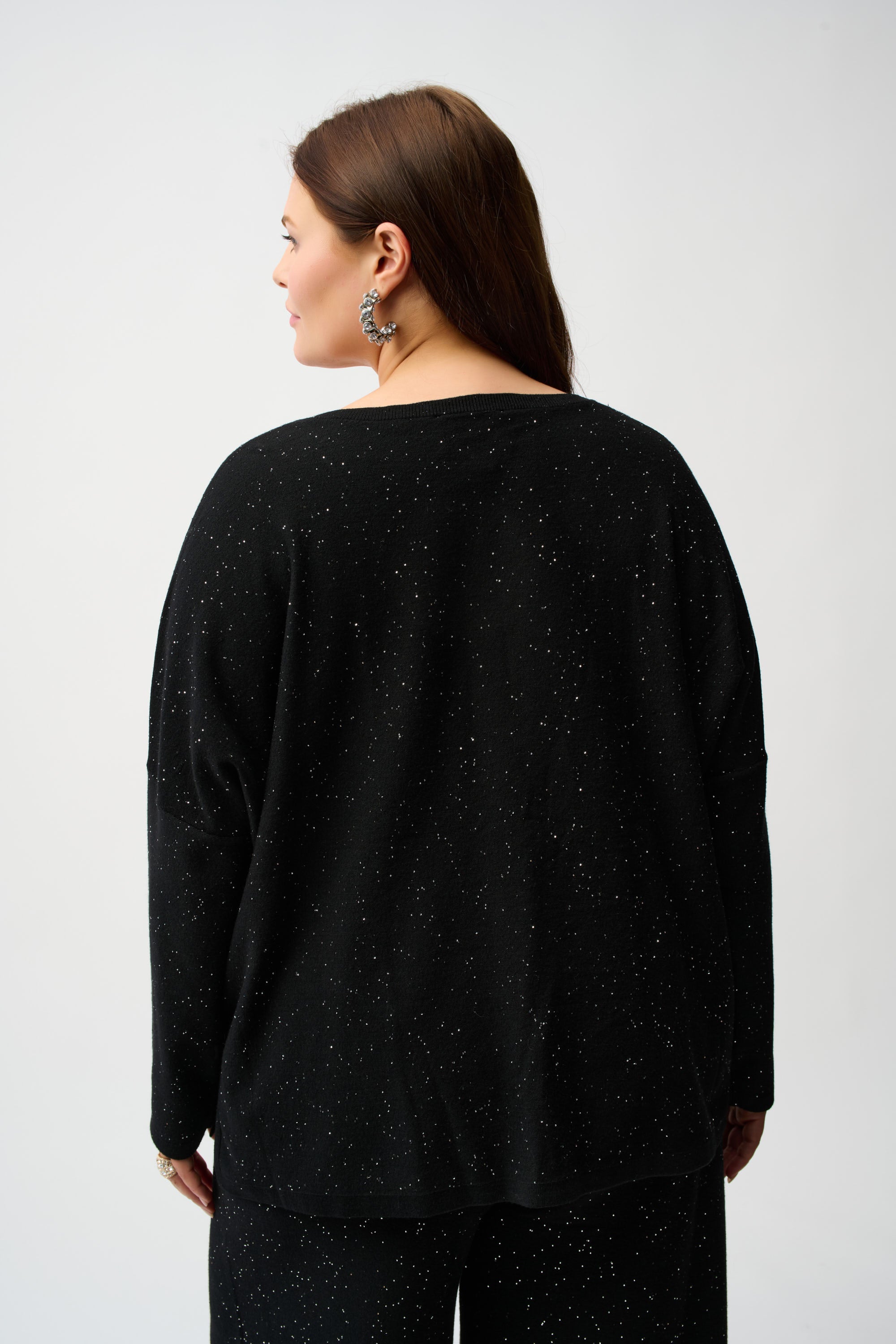 Back view of a model wearing a Sequined Sweater Knit Top with a relaxed fit and micro-embellishments.