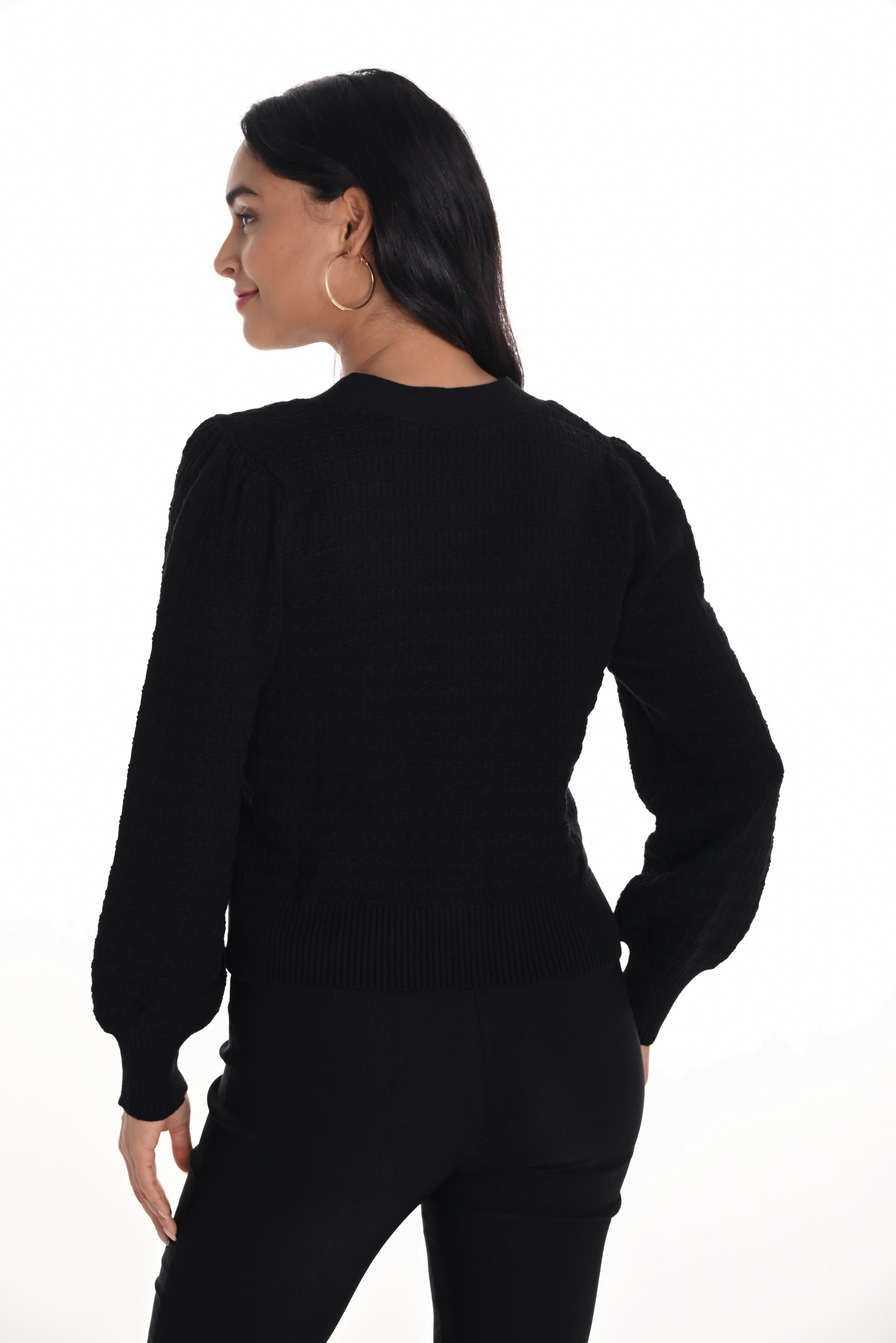 Person wearing a black sweater and pants on a white background