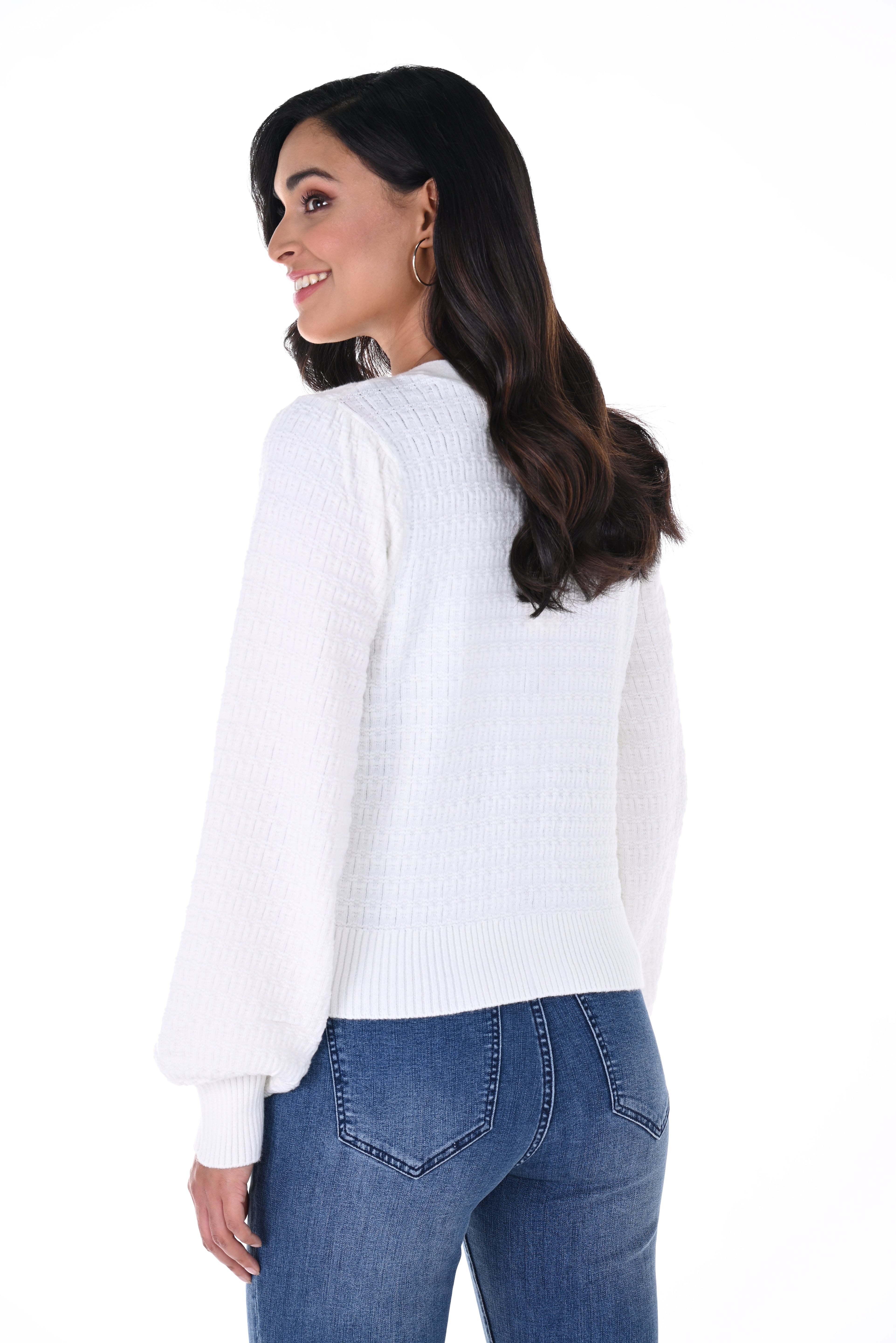 Woman wearing a white sweater and blue jeans on a white background