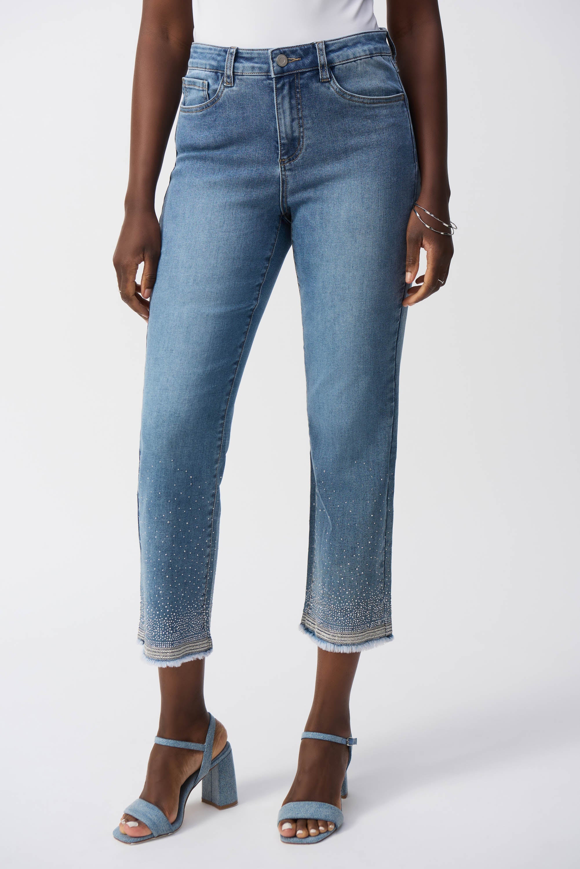 Front view of model in cropped straight jeans with five-pocket style and shimmering hem accents.
