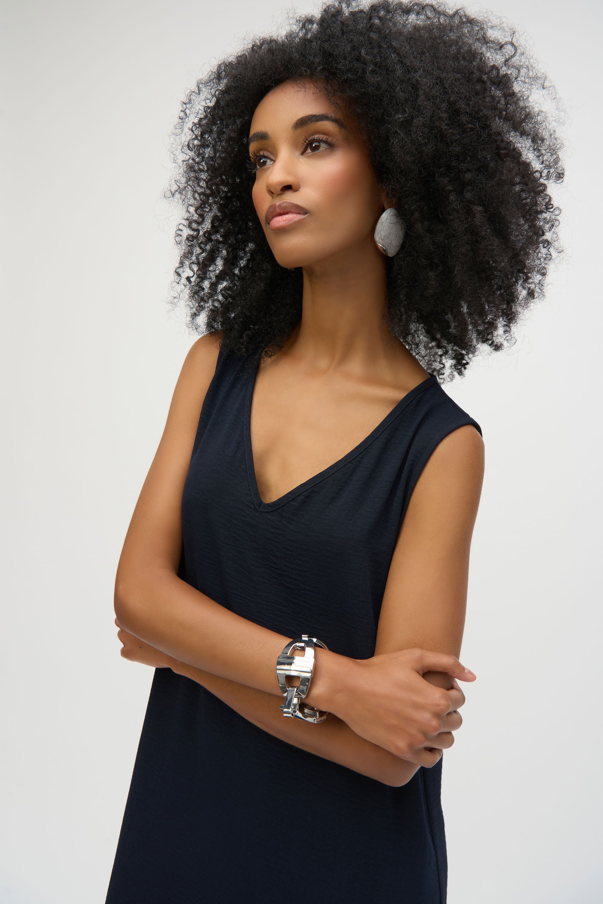 Close up of model wearing sleeveless midi dress with a navy upper bodice and V-neckline.