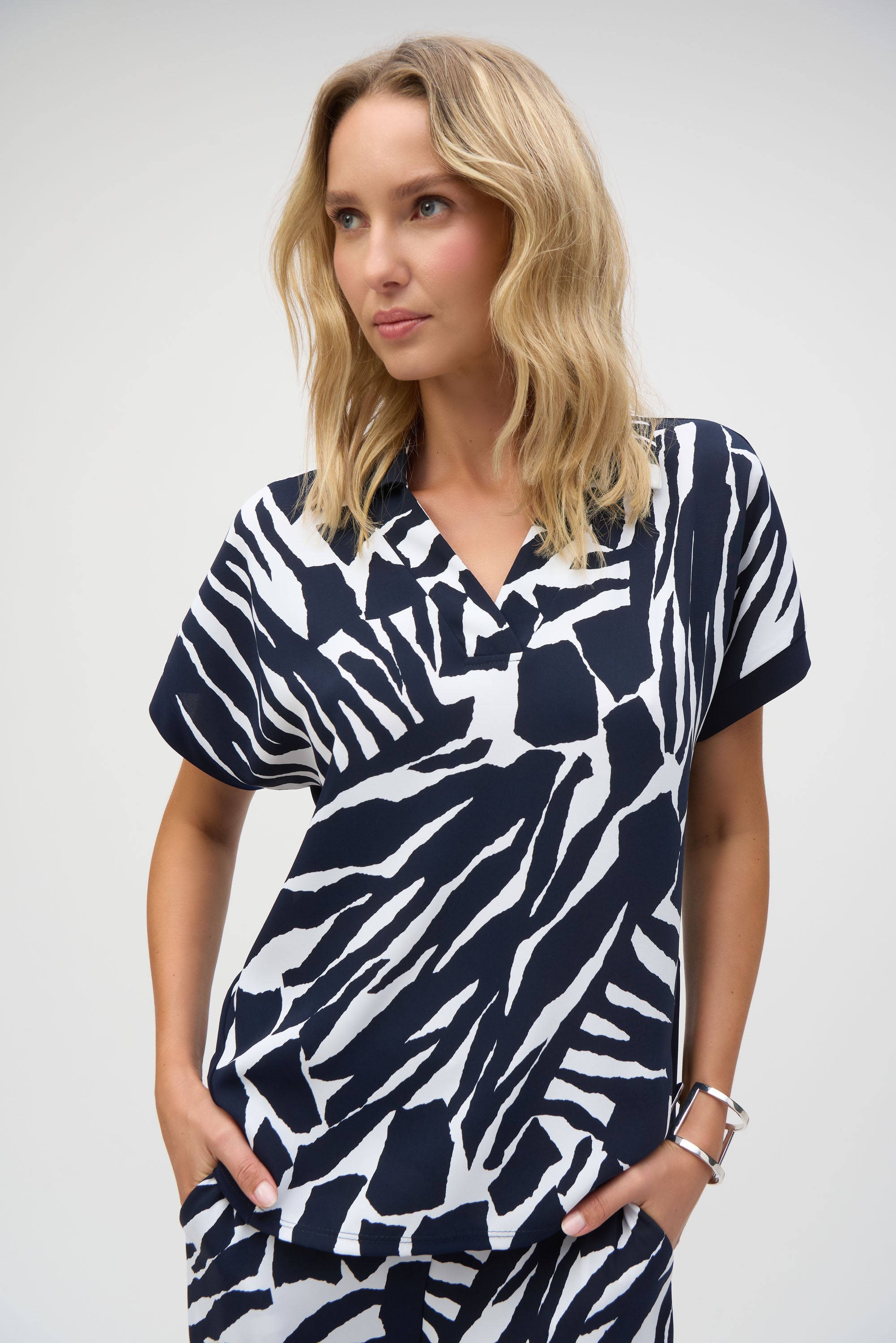 Close-up front view of the abstract print blouse showing the collar, V-neckline, and pattern detail.