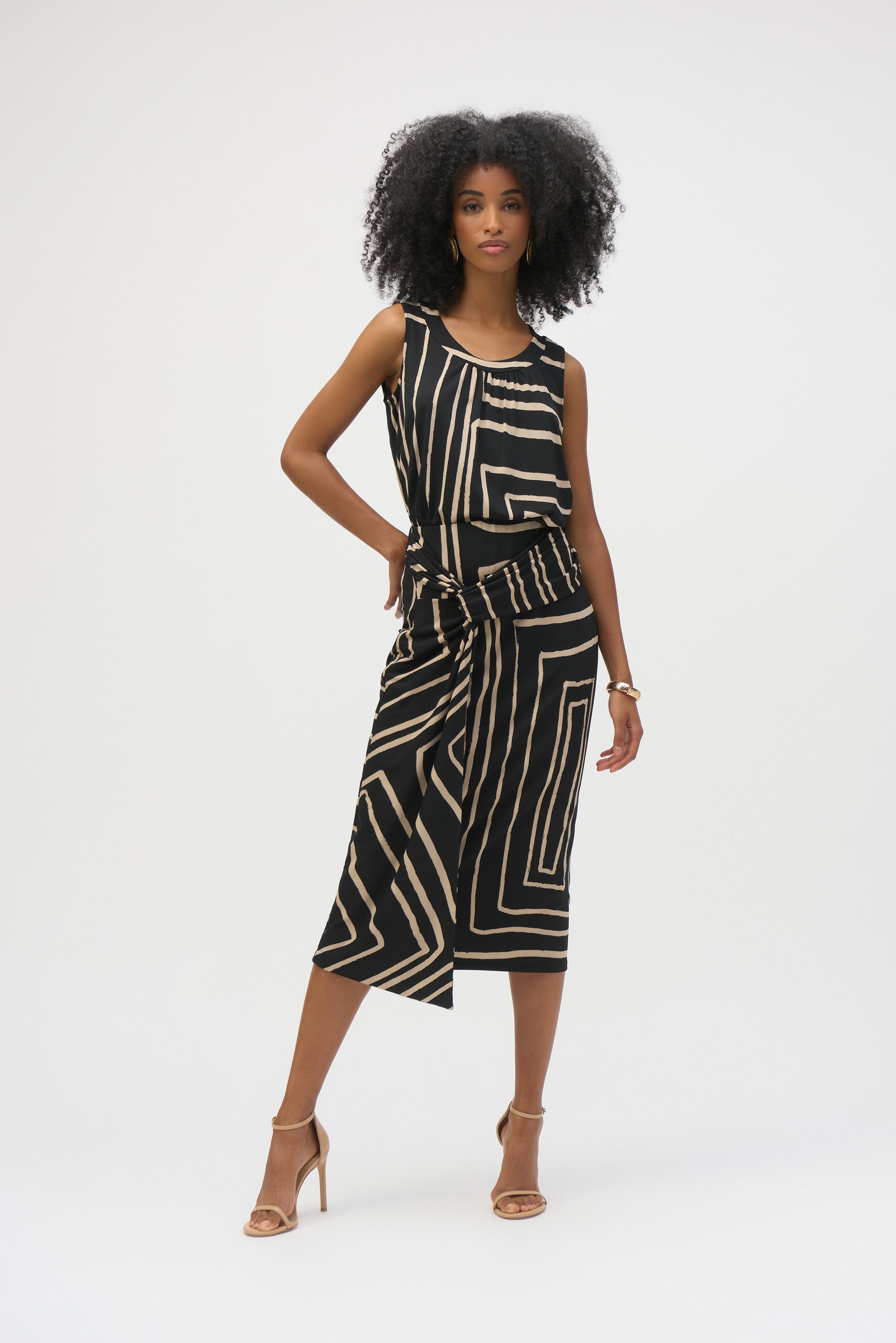 Woman wearing the full matching set, black and beige geometric print sleeveless top and skirt, posed confidently.