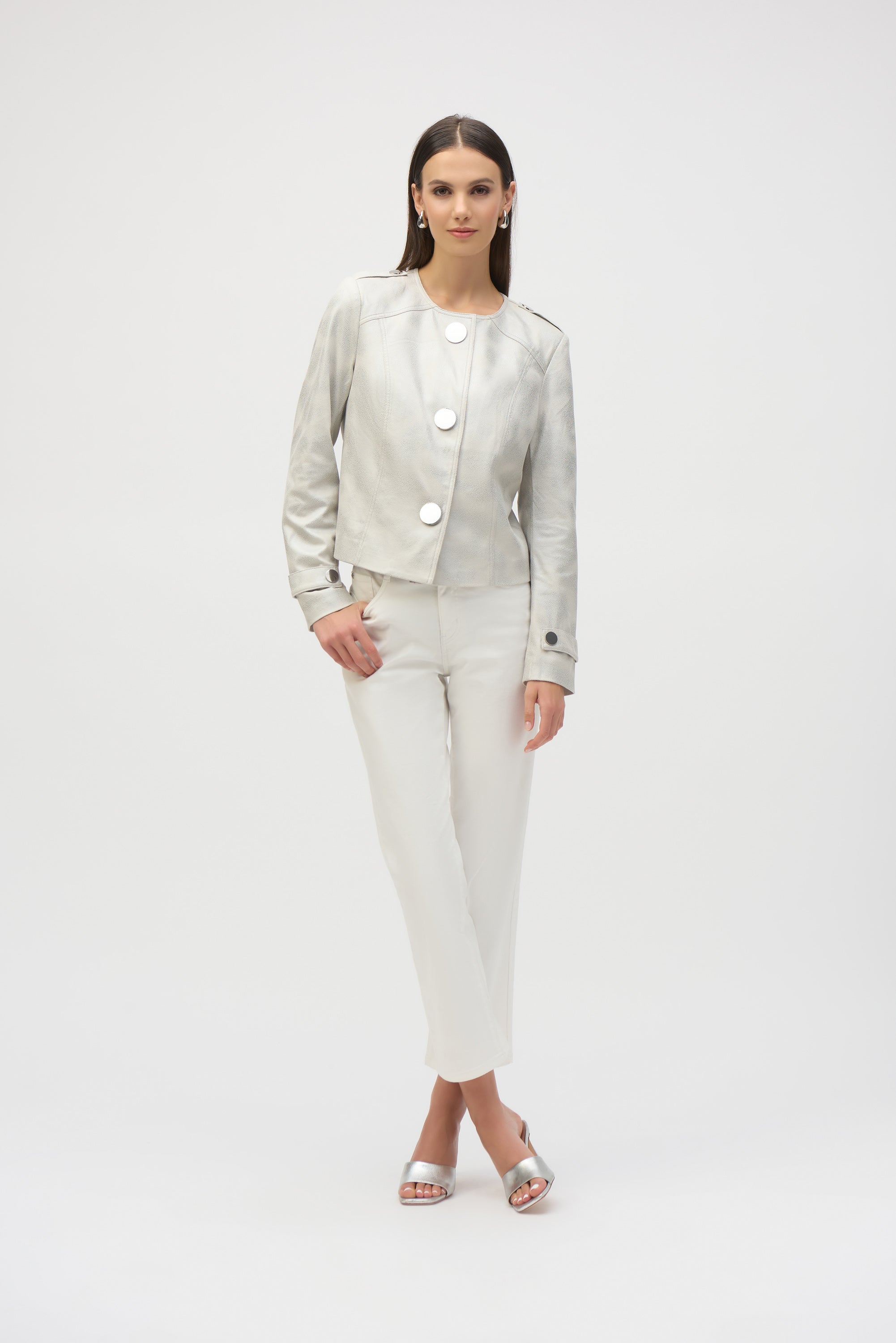 Woman wearing ivory faux suede boxy jacket with oversized buttons and ivory trousers, standing in full-length pose.