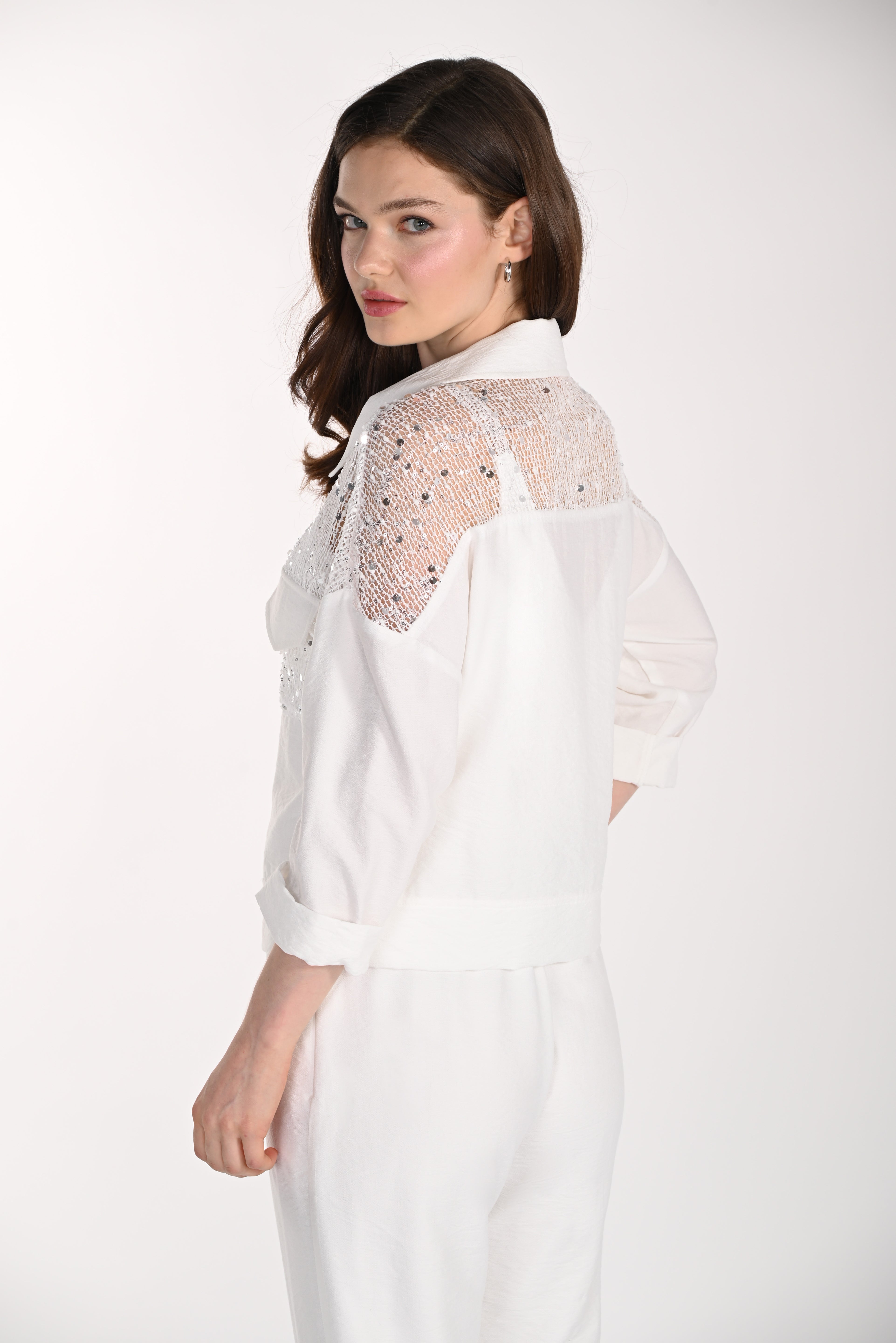 Model wearing a white jacket featuring a lace yoke with sequin embellishments, a relaxed fit, and rolled three-quarter sleeves, shown from the back and side.