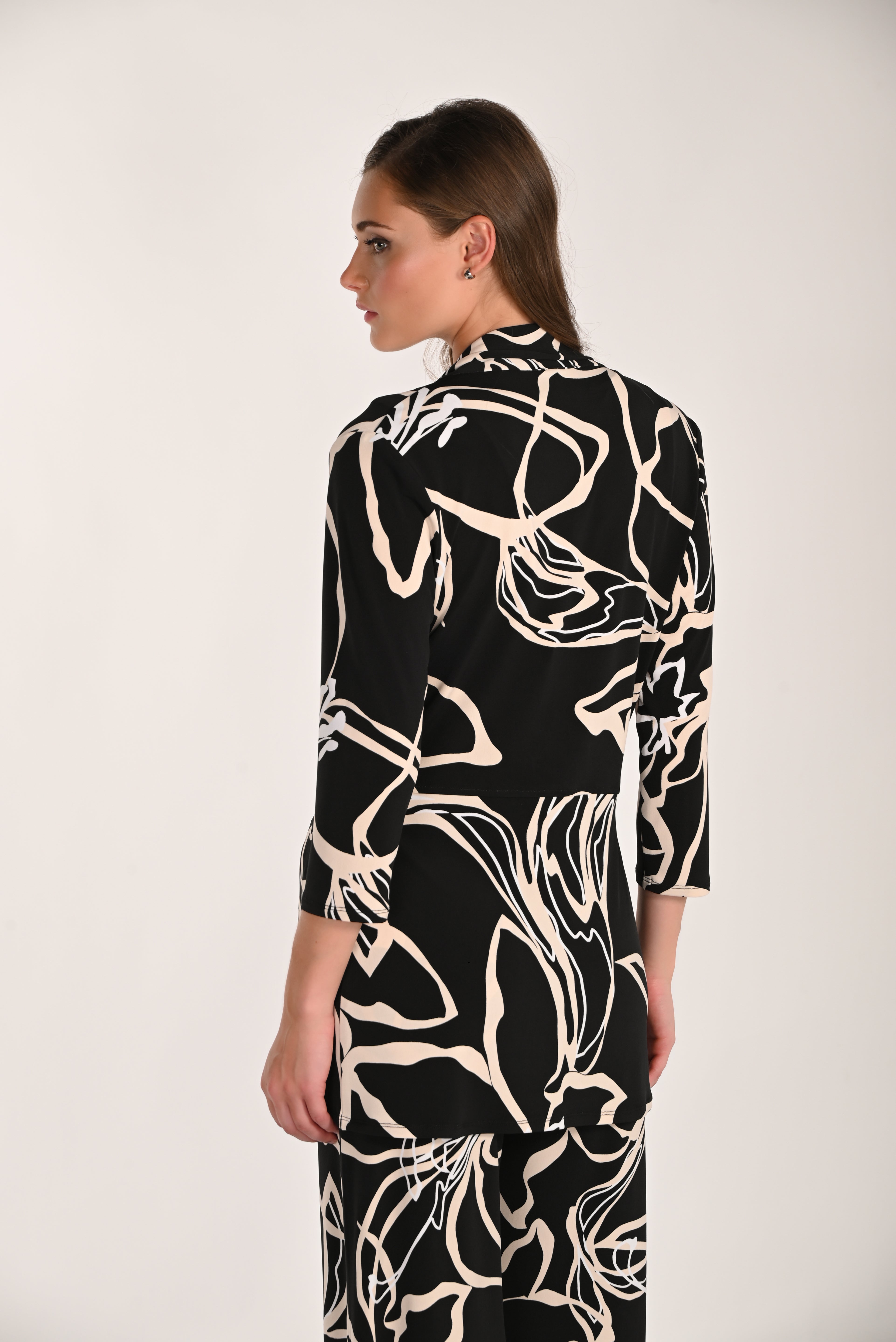 Back view of a women’s abstract print throw-over featuring a relaxed fit, soft stretch knit fabric, and three-quarter sleeves for easy layering and everyday comfort.