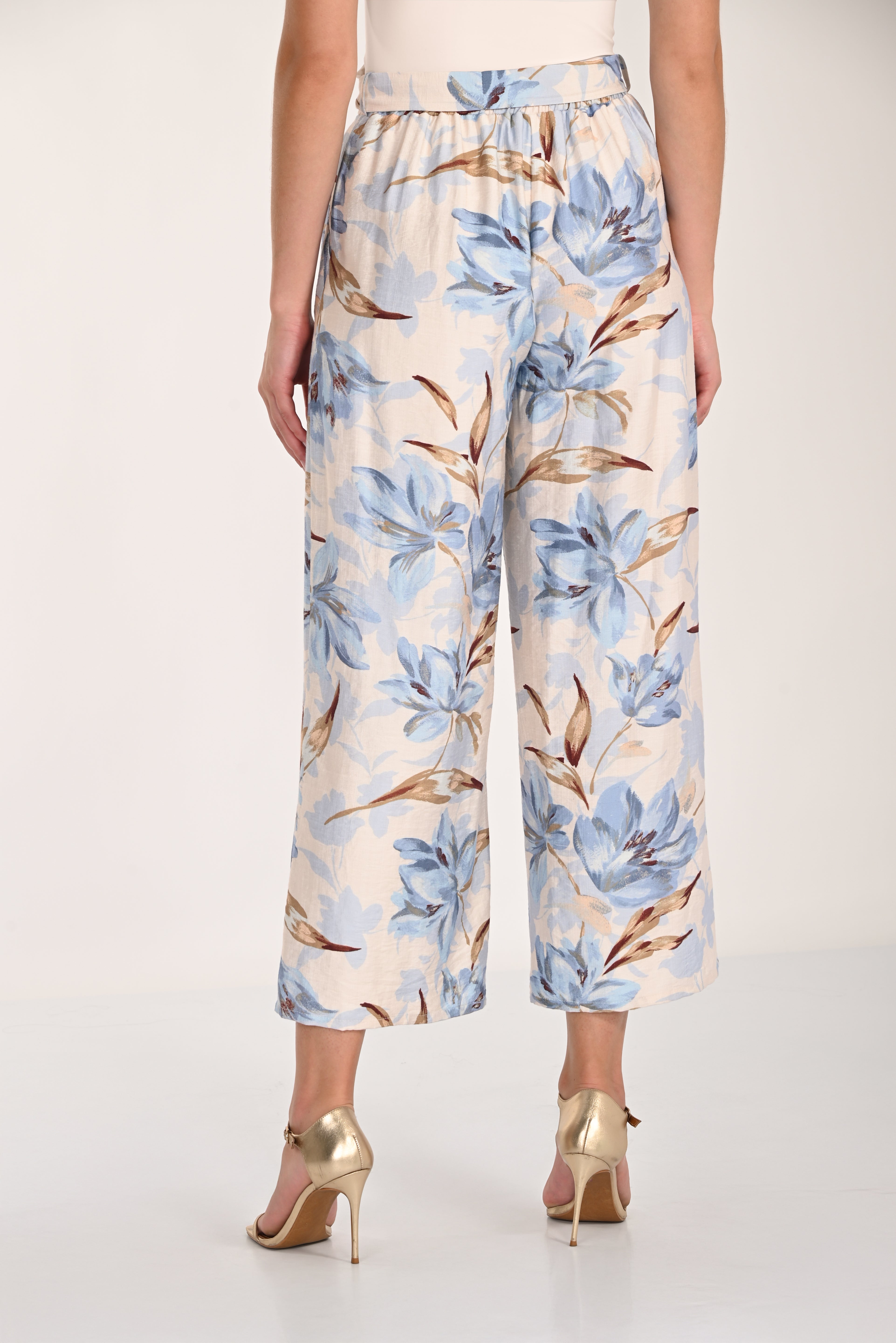Women's blue floral wide-leg cropped pants with an elasticized back waistband, wide-leg silhouette, and cropped length. Back view.