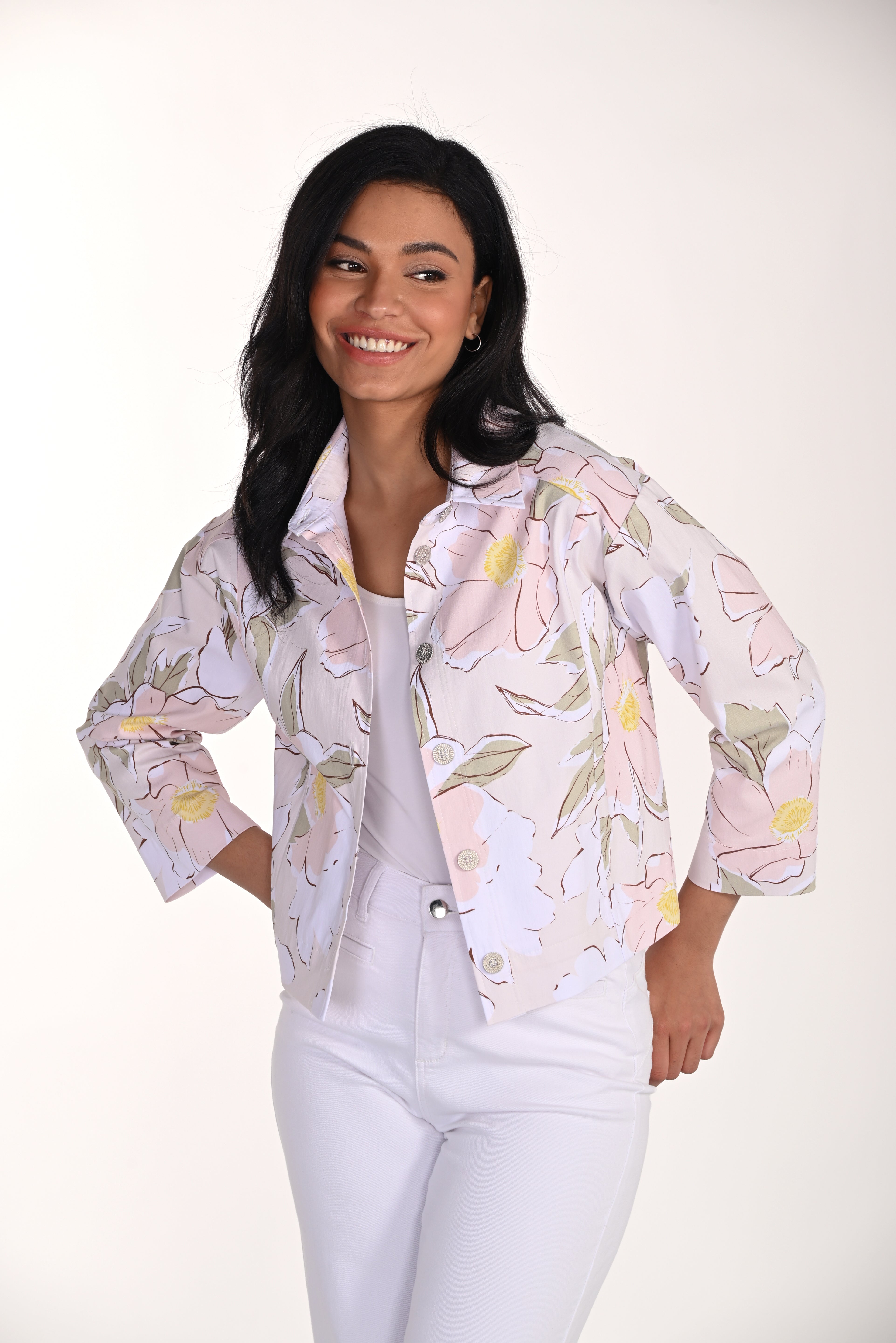 woman wearing a soft pink floral cropped jacket with button-front detail and white pants.