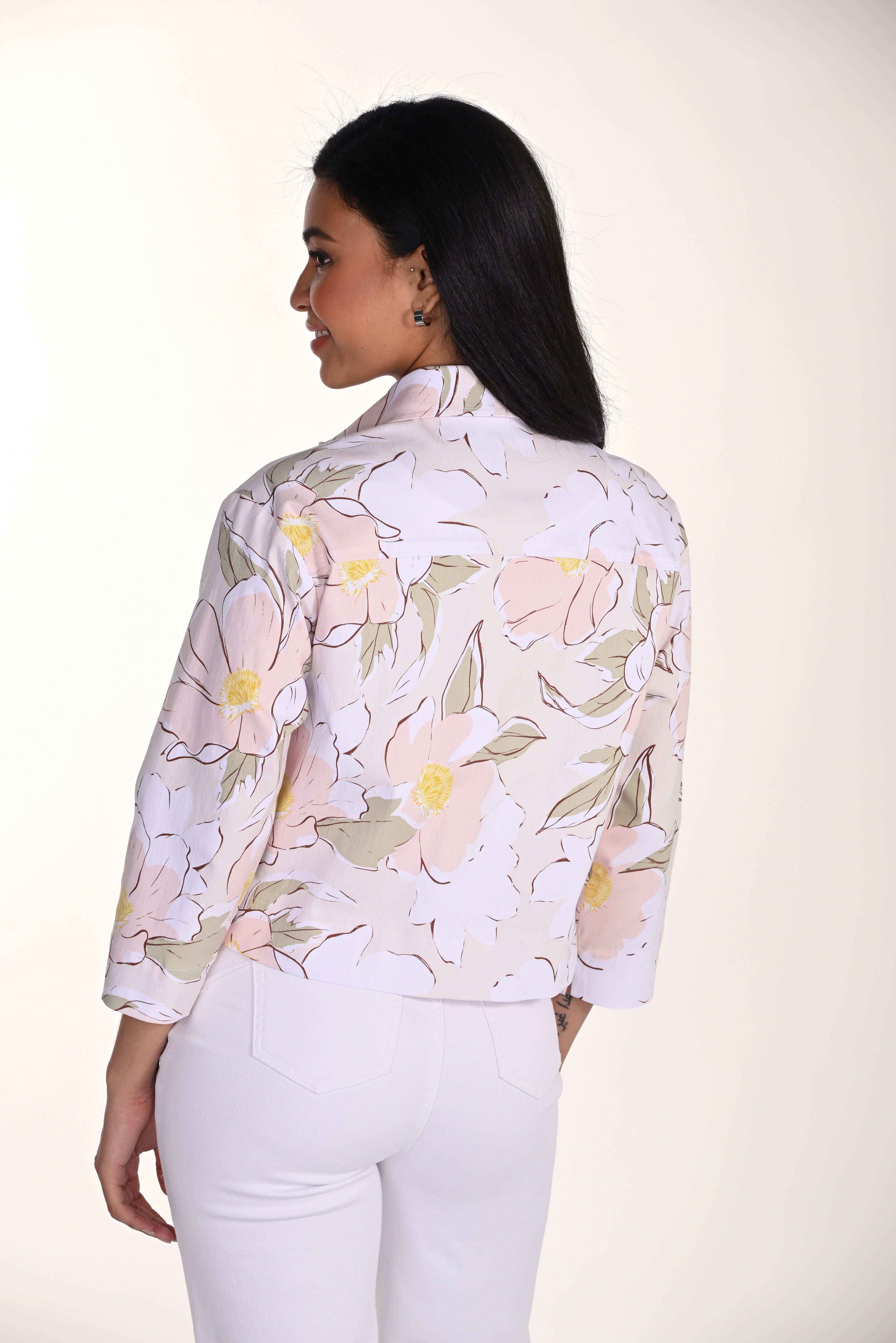 woman wearing a soft pink floral cropped jacket with button-front detail and white pants.