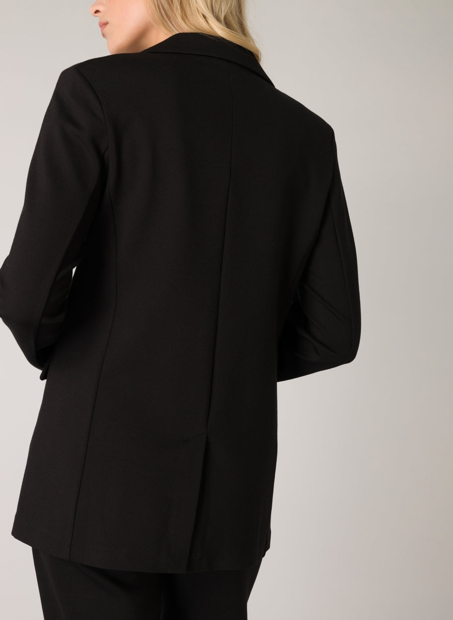 Back view of a black women's tailored blazer with a longline silhouette and clean, structured tailoring.