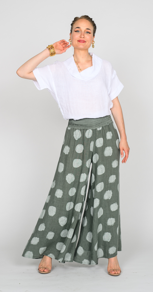 Woman wearing polka dot linen pants with a white top, showcasing the breezy, stylish design.