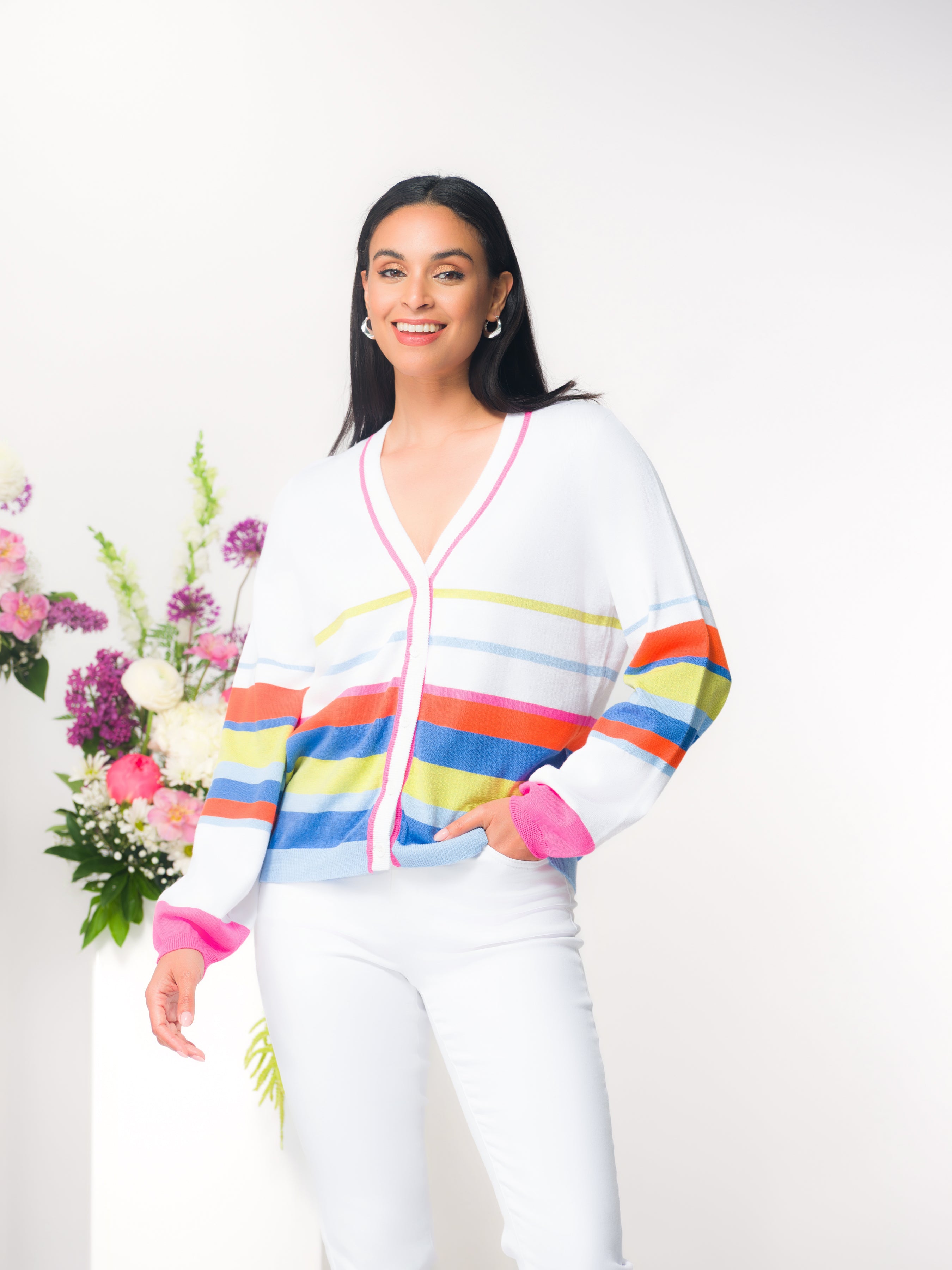 Model wearing a women’s striped cotton cardigan with a button-front design and relaxed fit, styled with fitted pants in a studio setting.