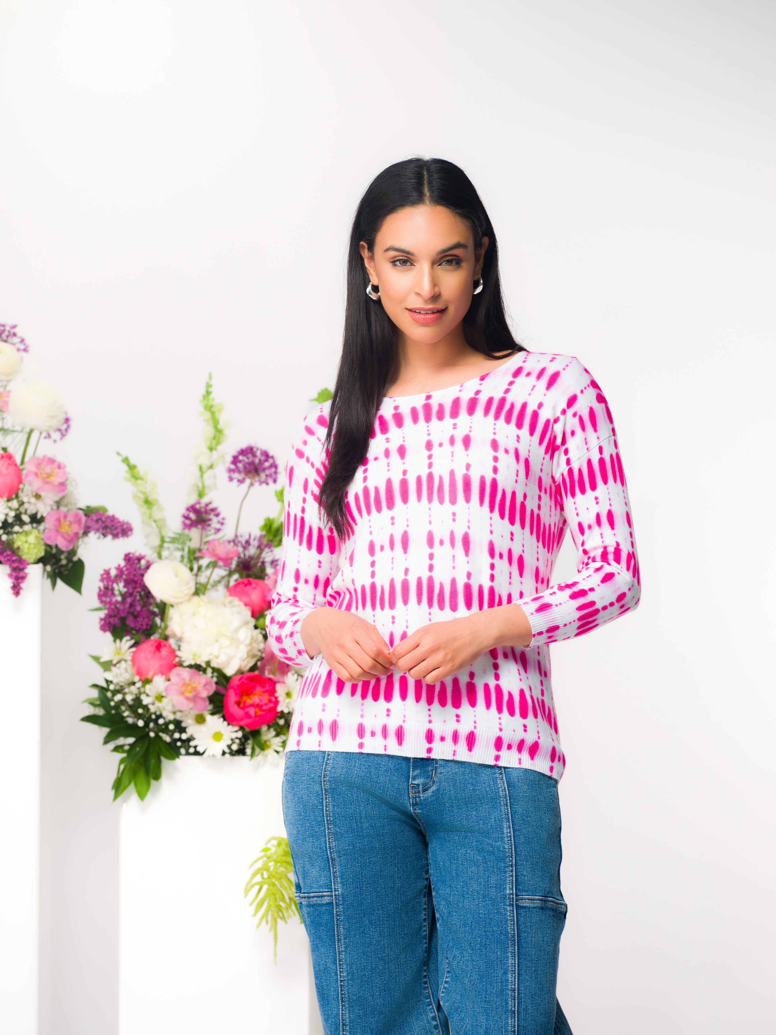 Model wearing a women’s long-sleeve knit pullover with a soft drape and classic neckline, styled for an everyday polished look.