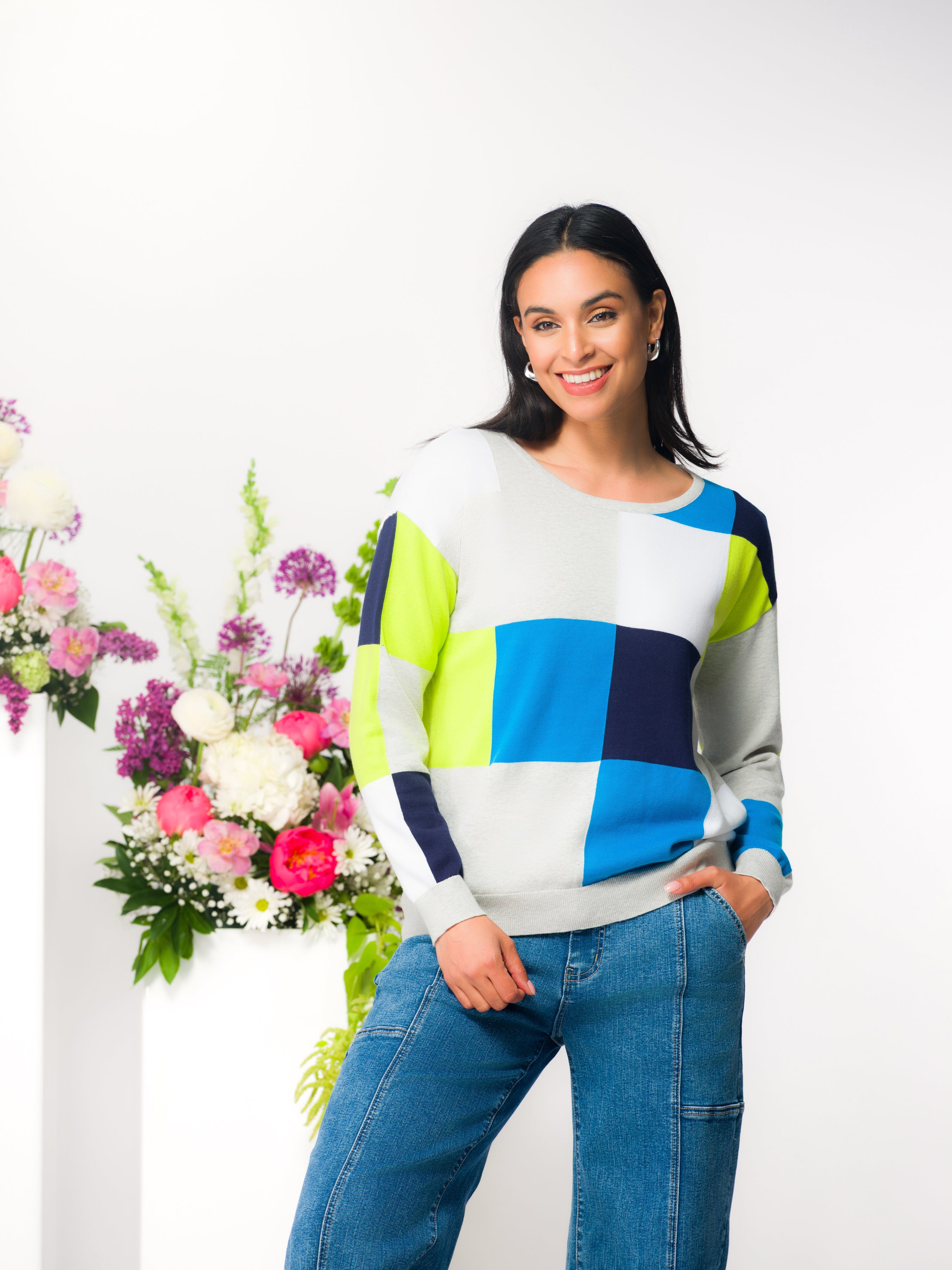 Women’s relaxed-fit crewneck cotton sweater styled with wide-leg jeans, shown on model in a studio setting.