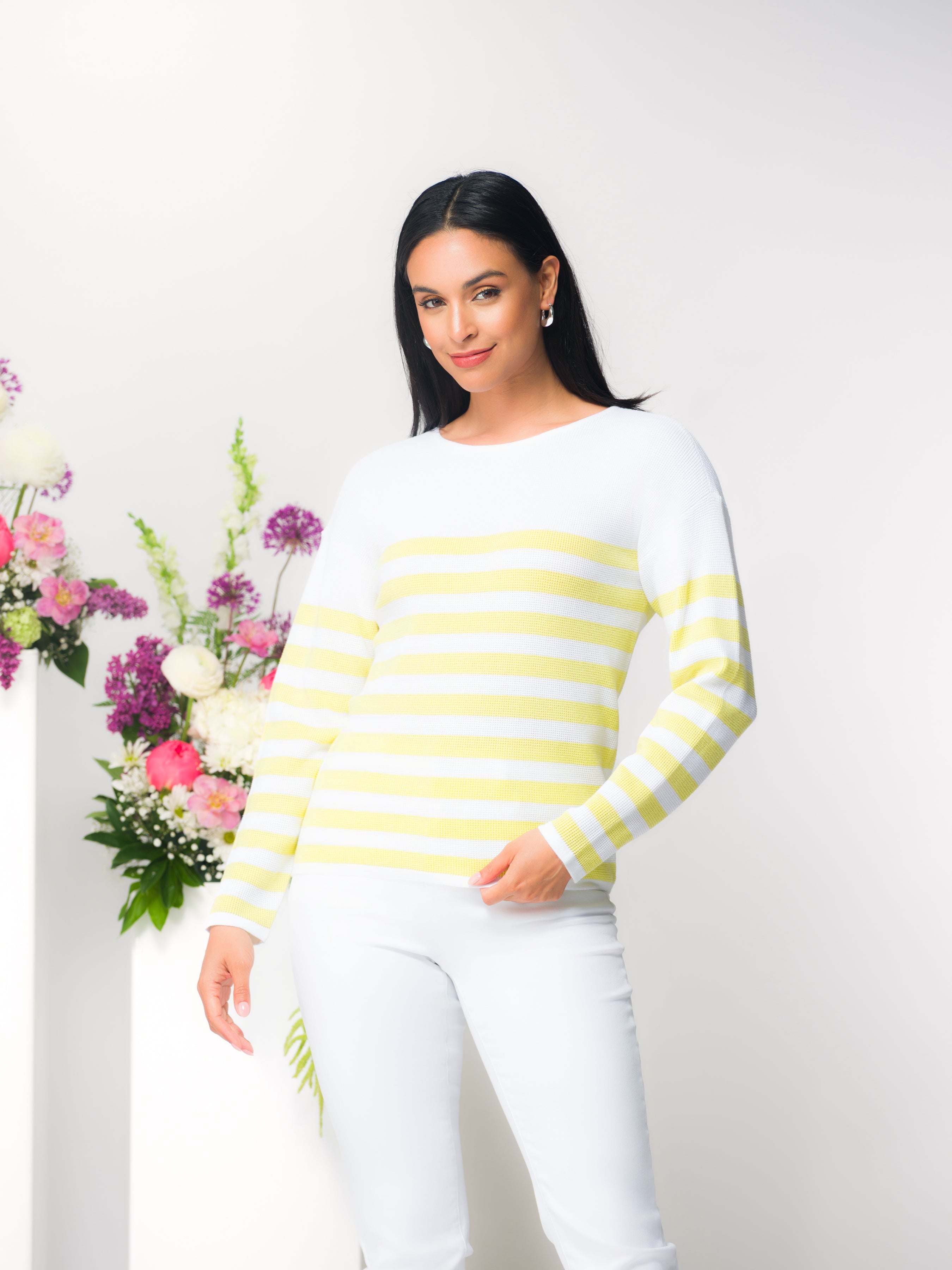 Women’s long sleeve striped sweater in white with soft yellow stripes, relaxed fit crew neckline, styled with white pants.