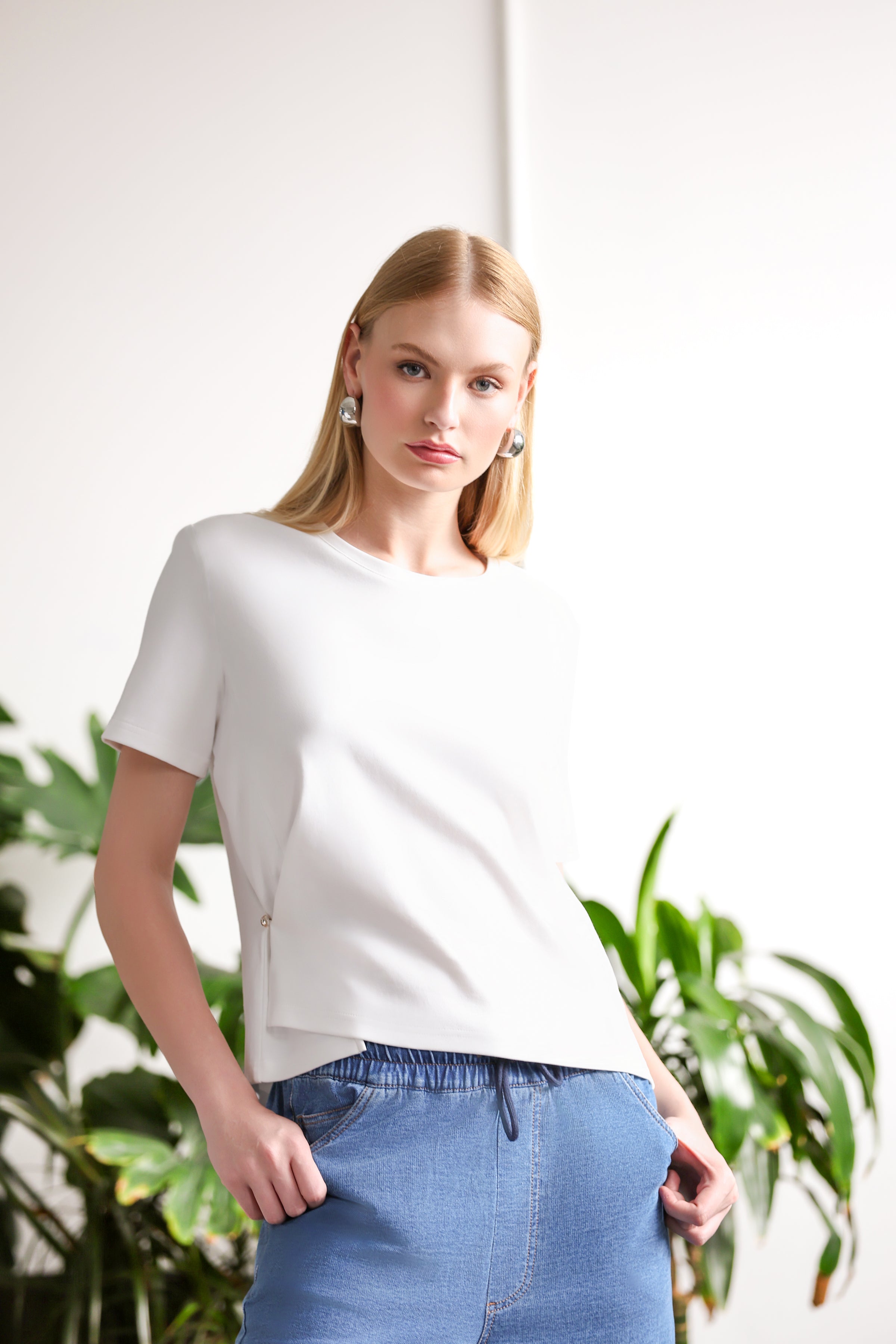 Women’s ivory short-sleeve crew neck t-shirt with side accent detail, paired with light blue denim jogger-style jeans.