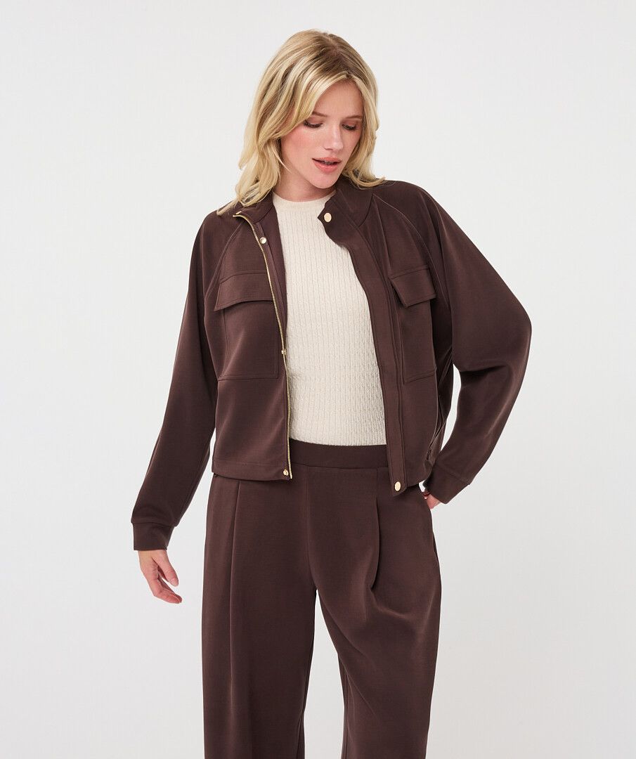 Full-length view of a woman wearing a chocolate brown utility jacket with matching wide-leg trousers