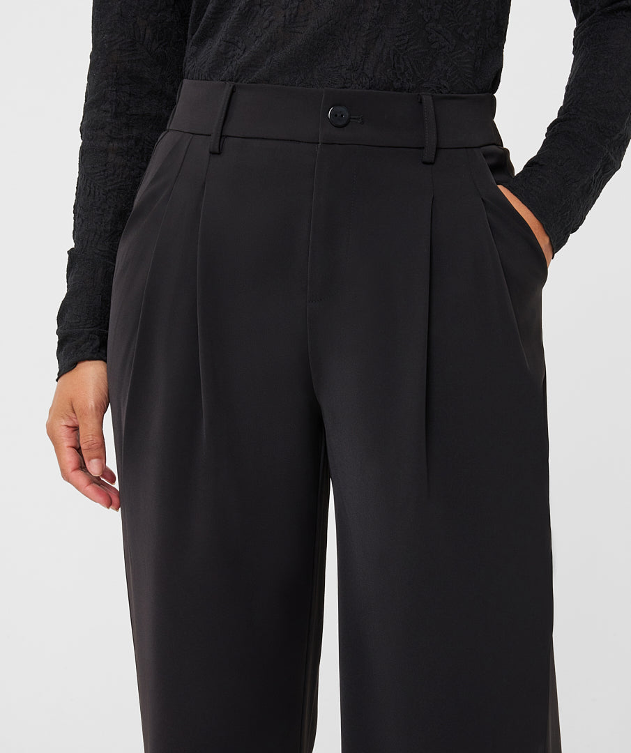 Model wearing black wide-leg trousers
