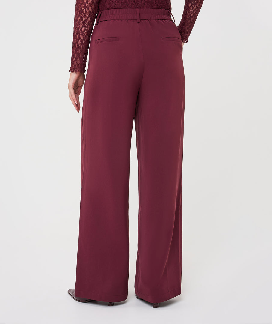 Model wearing merlot wide-leg trousers