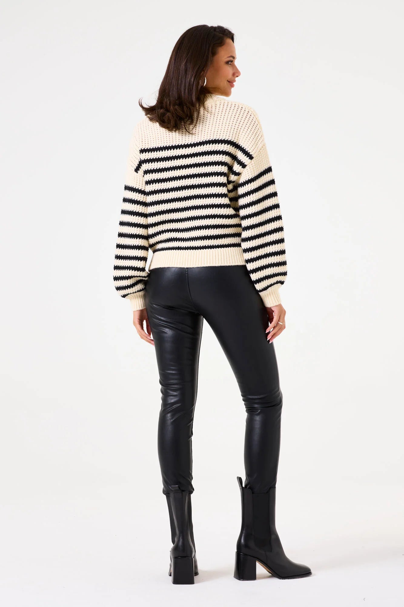 Model wearing high-waist City Edge vegan leather legging with a striped oversized sweater.