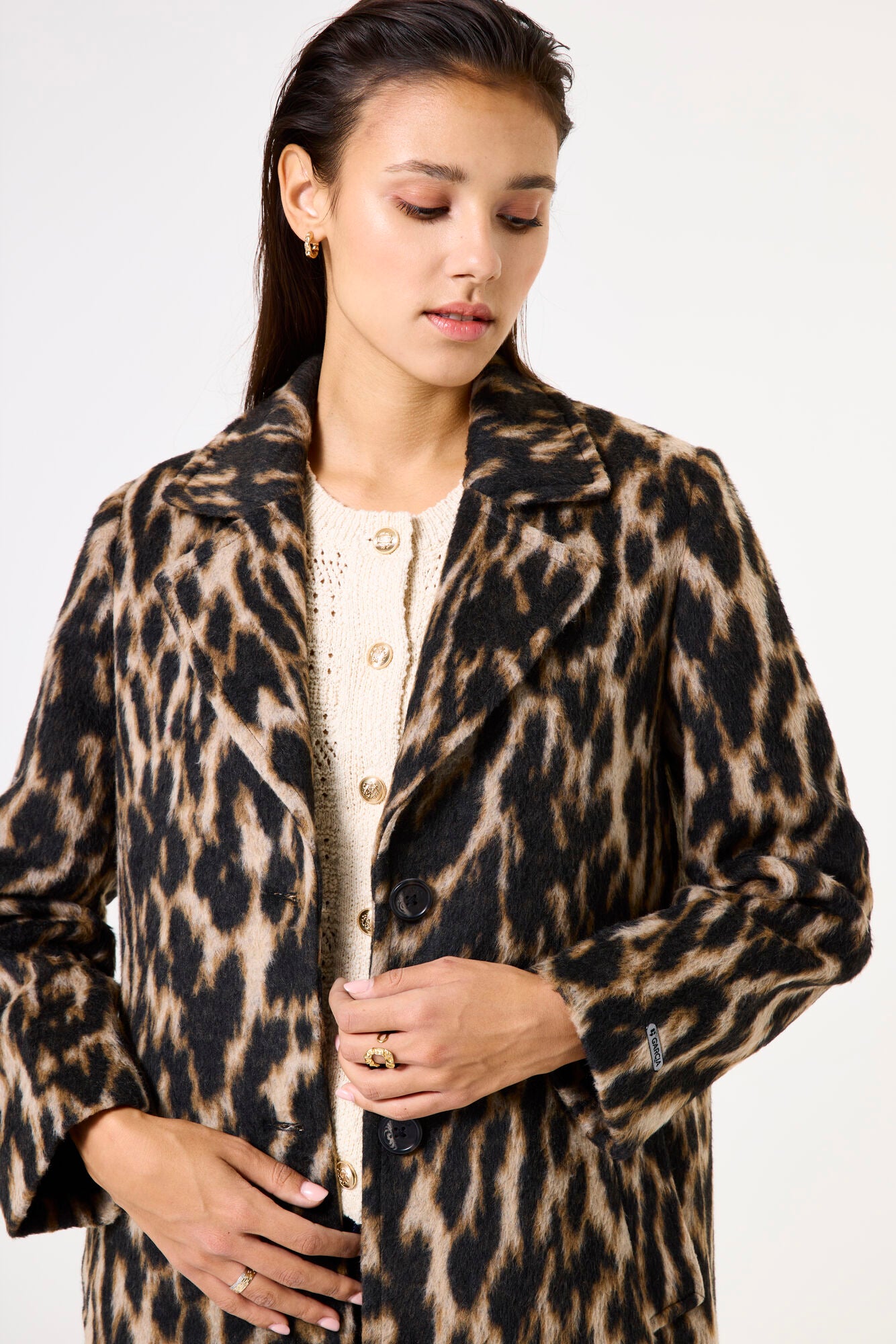 Woman wearing a leopard print coat on a white background