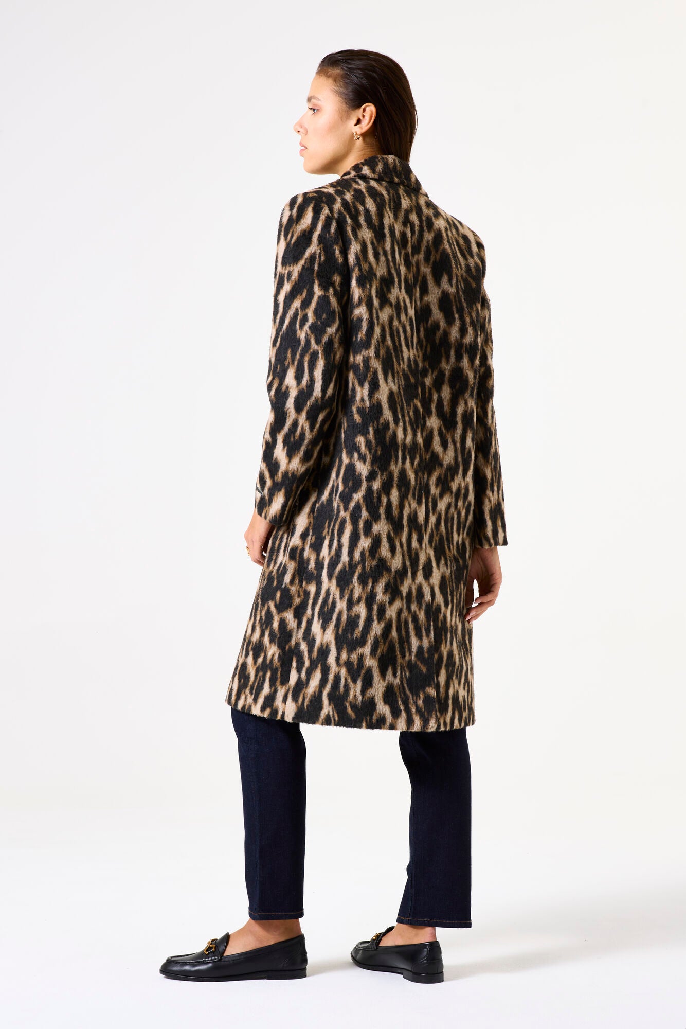 Person wearing a leopard print coat on a white background