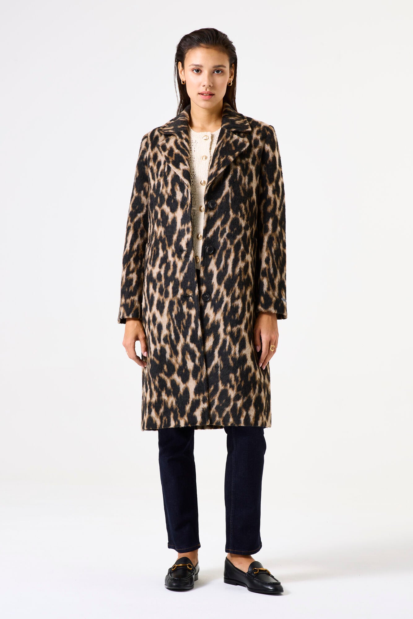 Woman wearing a leopard print coat on a white background