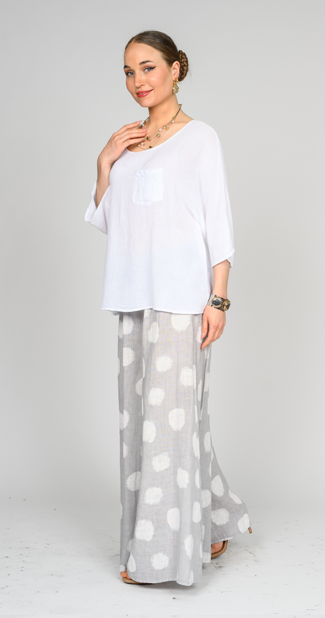 Model wearing polka dot linen pants paired with a loose white top, showcasing a stylish, breezy look.