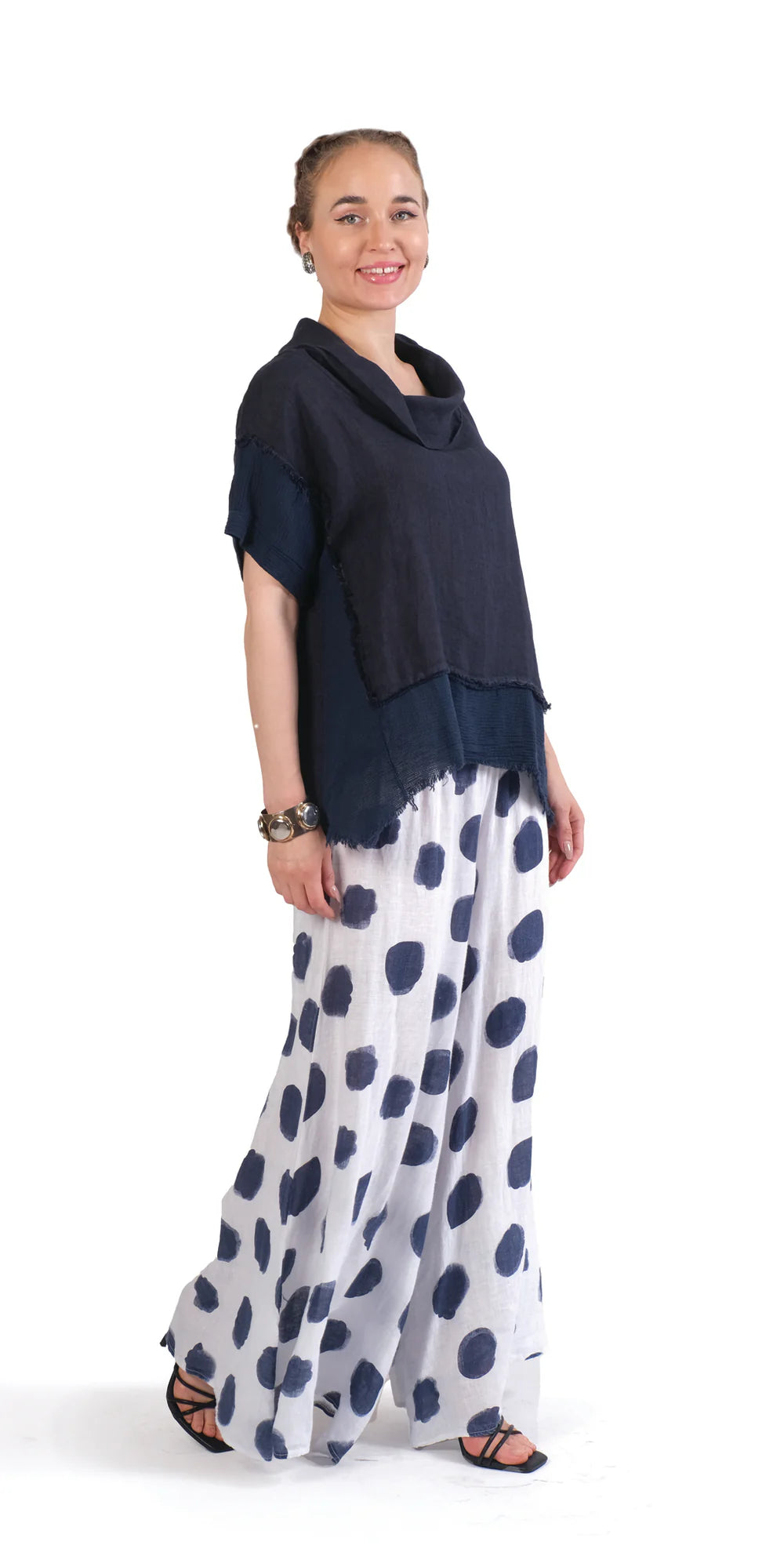 Stylish woman wearing polka dot linen pants with a dark navy top, showcasing breezy and elegant fashion.