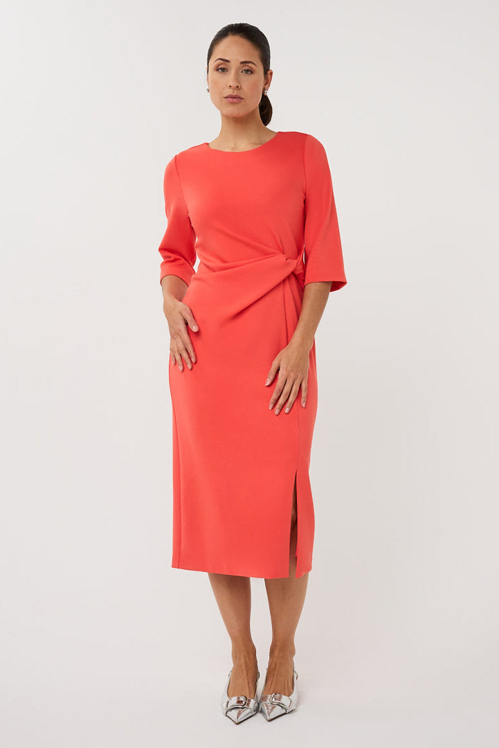 Woman wearing a coral dress with a plain background