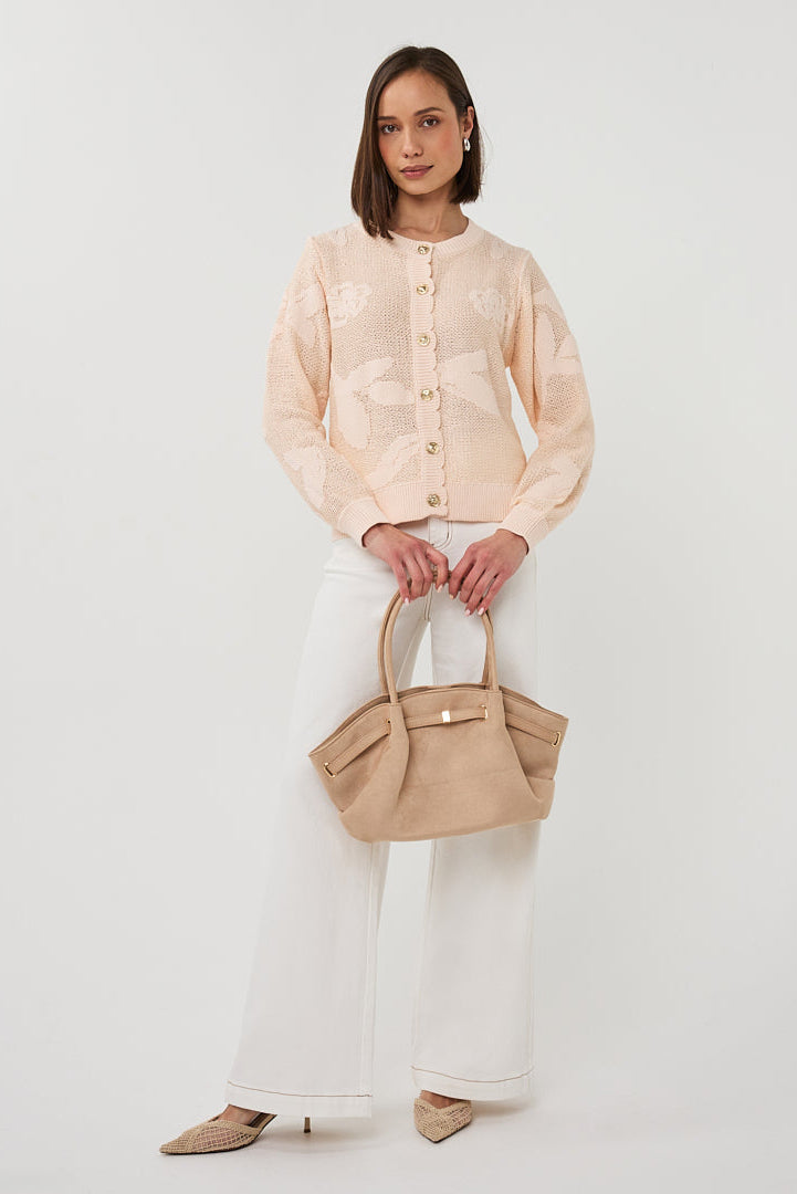 Woman holding a beige handbag against a white background
