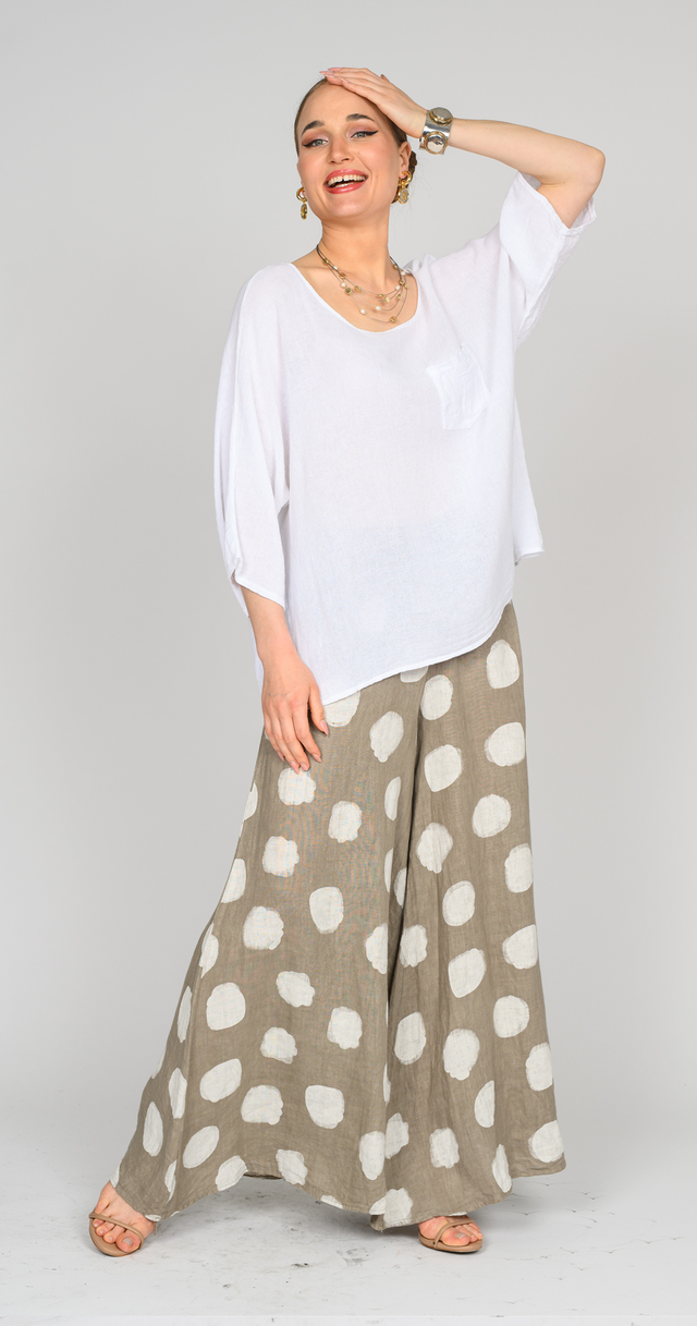 Model wearing polka dot linen pants with a white top, showcasing coastal charm and stylish elegance.