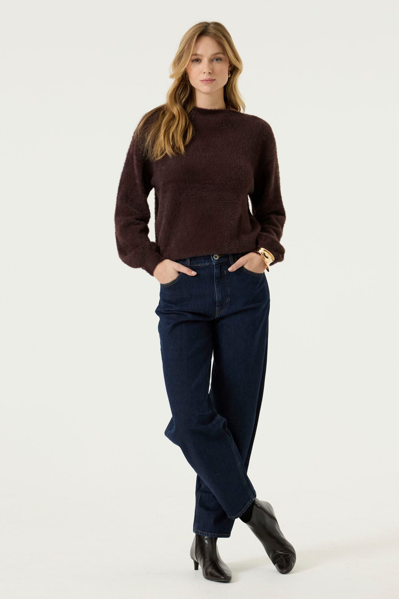 Model wearing the Alora Soft Texture Sweater in rich brown, featuring a relaxed silhouette, soft textured knit, and long sleeves, paired with dark wash jeans.