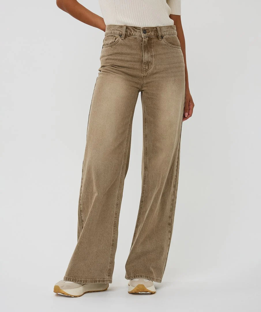 Brown wide-leg jeans worn by a person on a white background