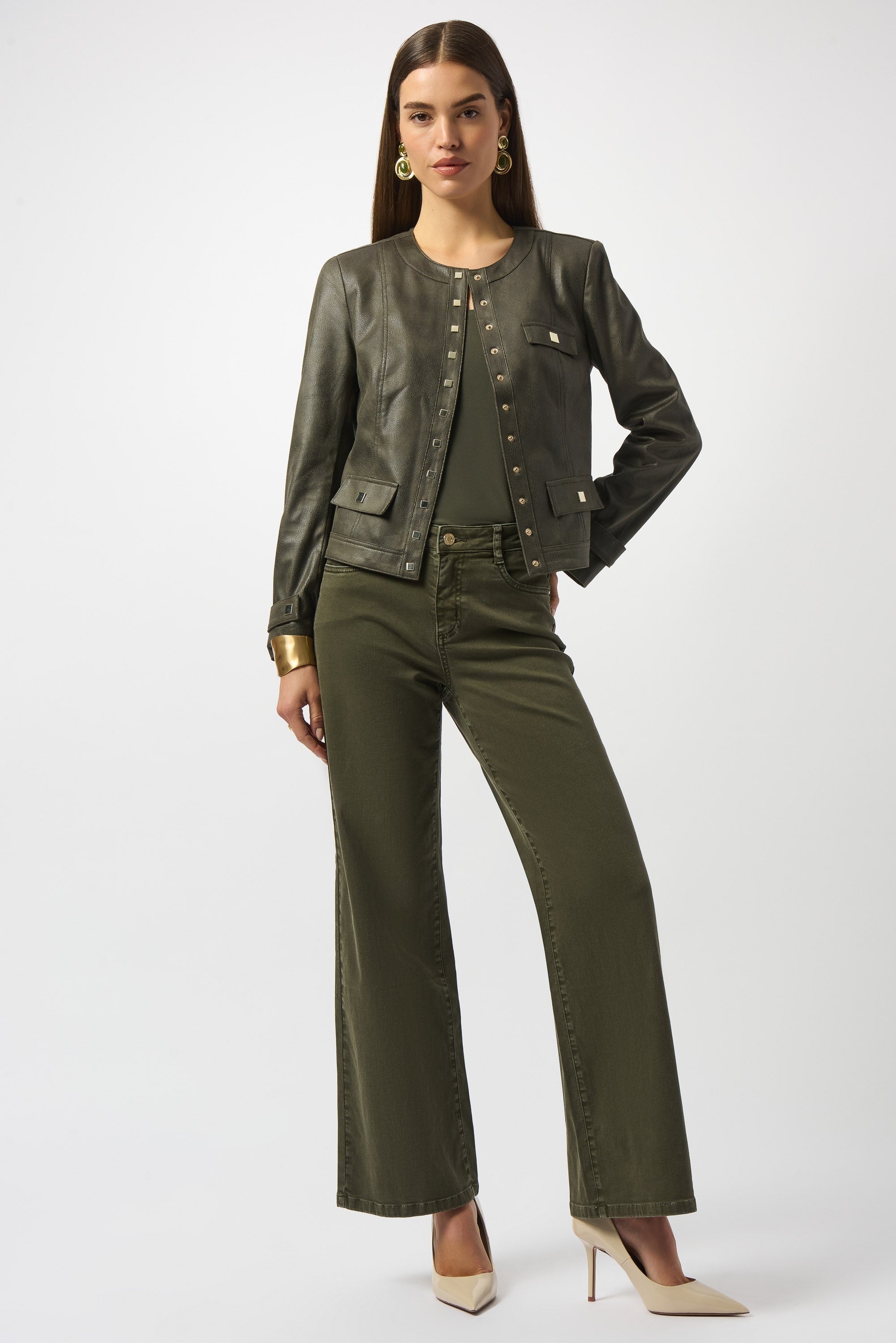 woman standing in a dark-green outfit wearing a jacket and pants