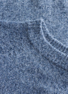 Close-up of blue-grey textured knit fabric with a soft, brushed finish and subtle tonal variation.
