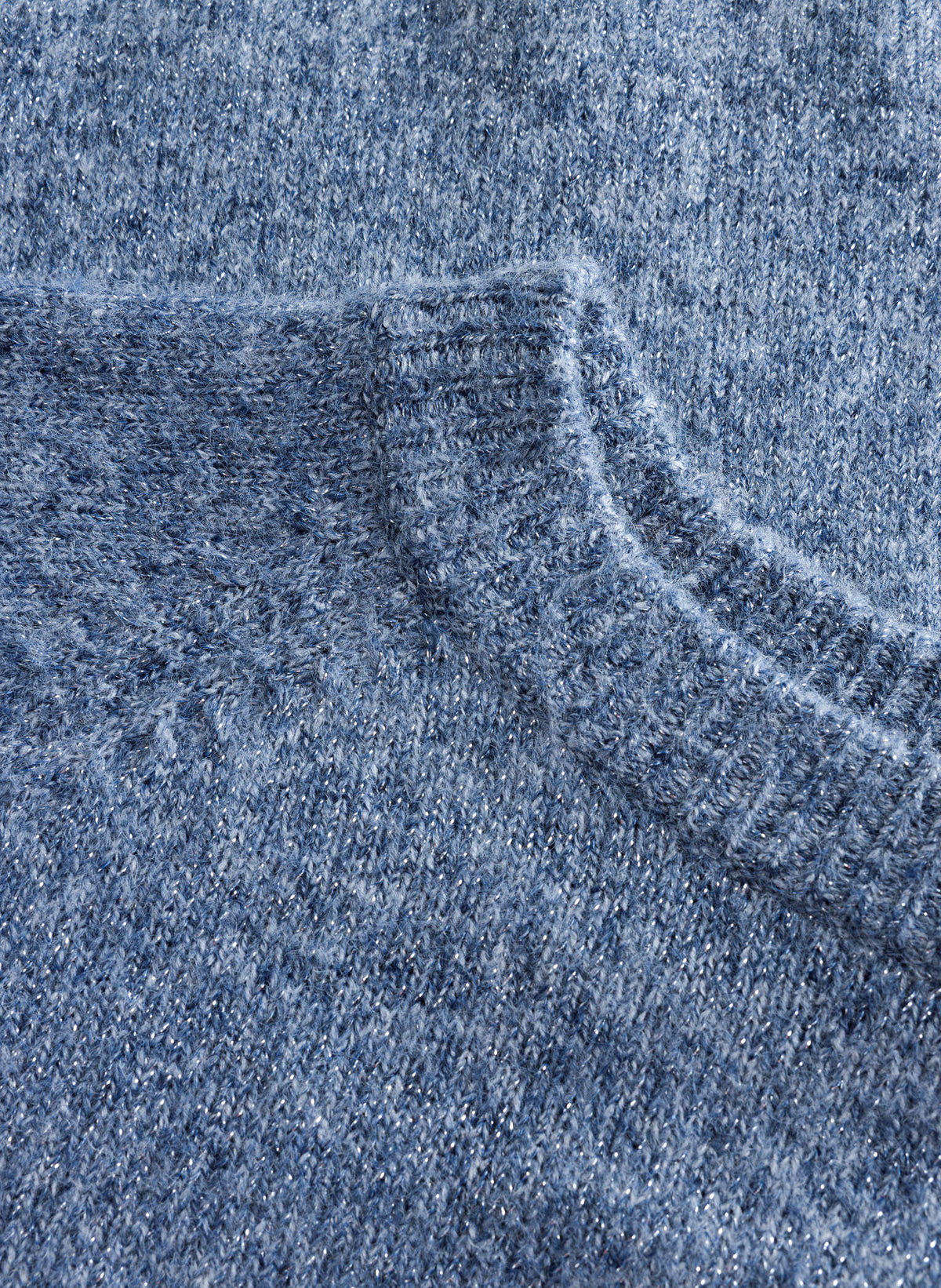 Close-up of blue-grey textured knit fabric with a soft, brushed finish and subtle tonal variation.