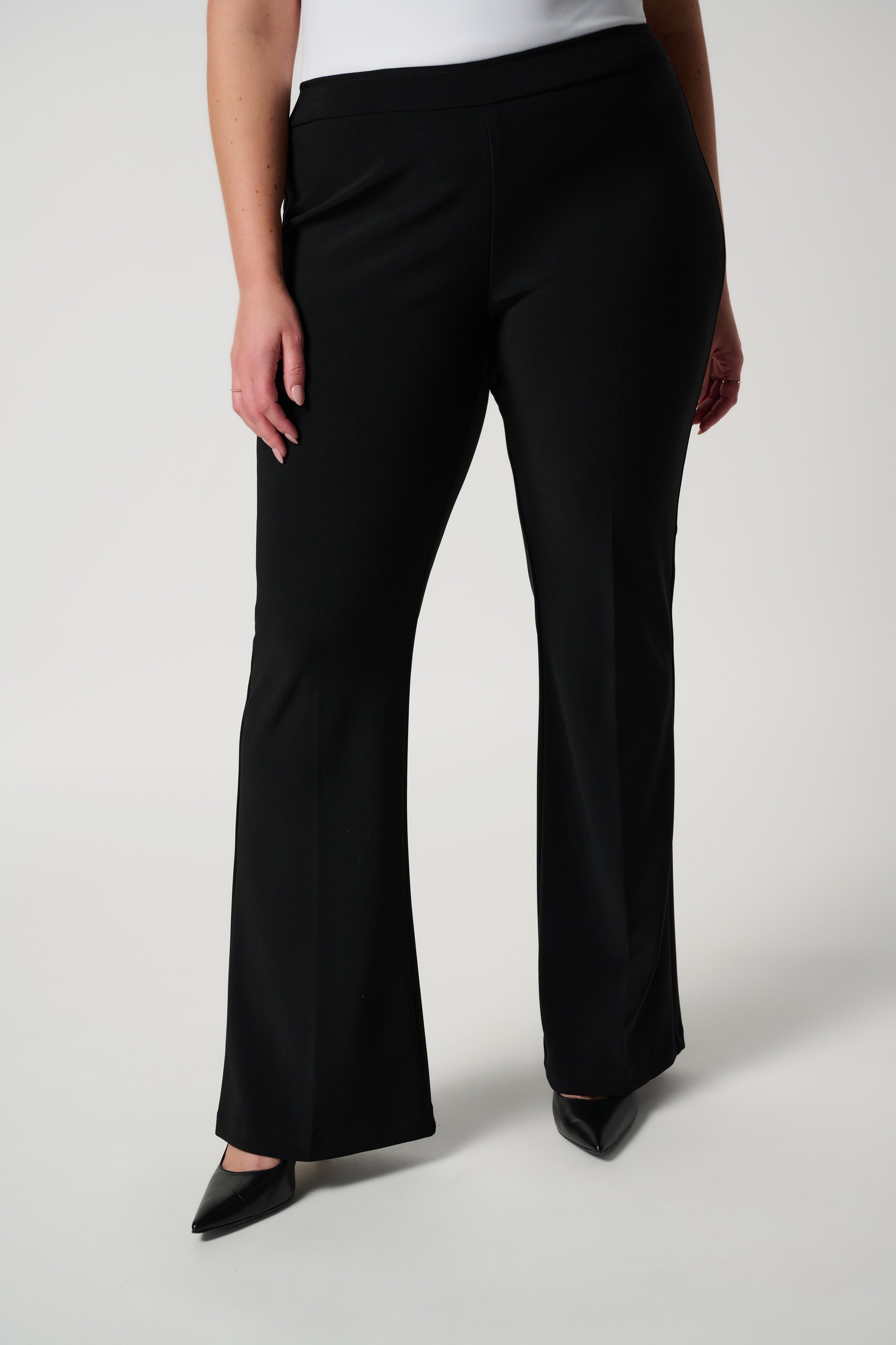 Black flare pants on plus sized model, shot of pants only
