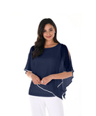 Woman wearing a navy cold-shoulder chiffon overlay top with an asymmetrical hem and wide-leg trousers against a light background.