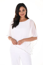 Woman wearing a white cold-shoulder chiffon overlay top with an asymmetrical hem and wide-leg trousers against a light background.