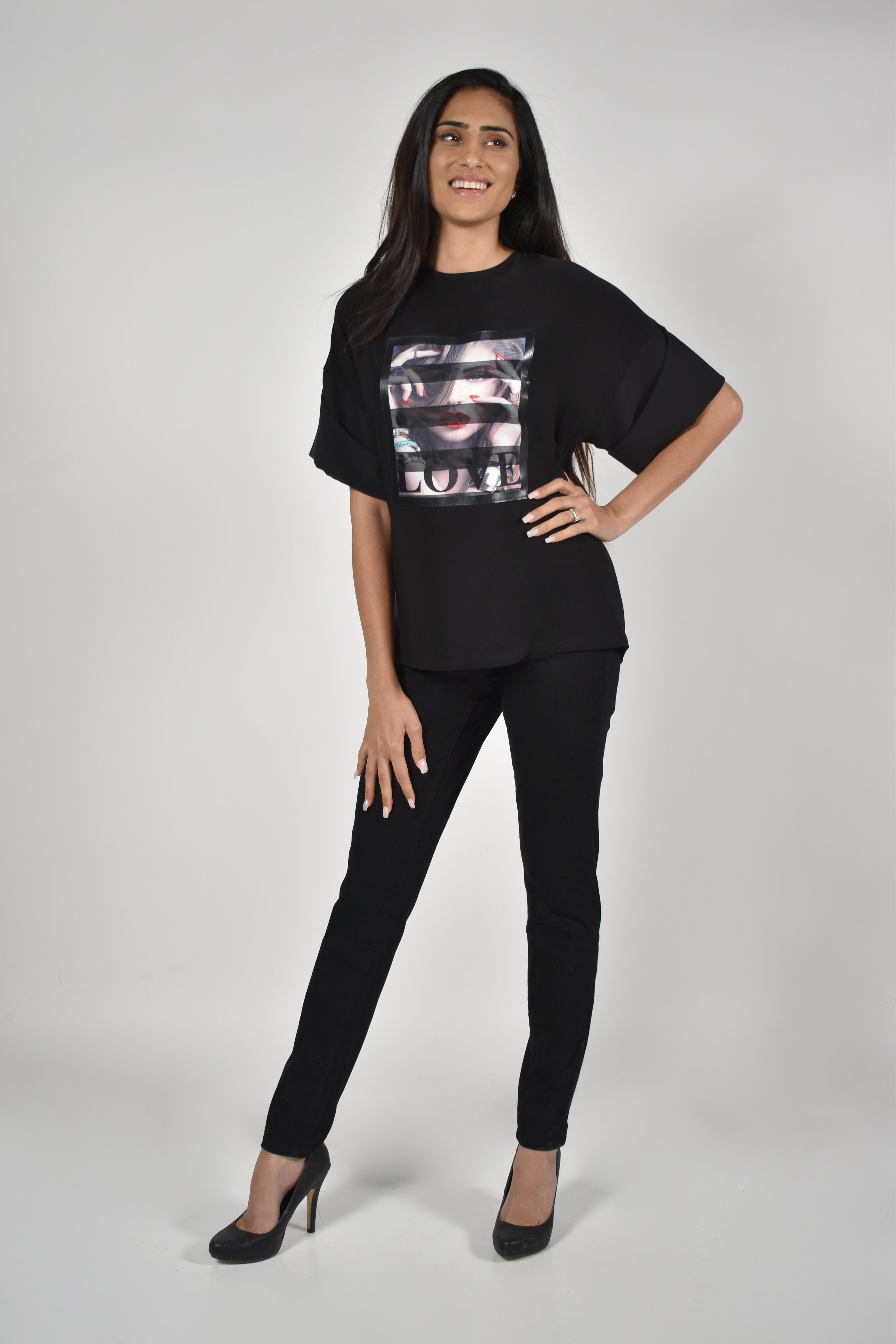 Model wearing high-rise comfort stretch slim jeans with a stylish black top and high heels.