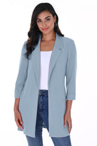 Woman wearing the sky blue Cleo Longline Blazer with a relaxed open-front design, rolled cuff sleeves, and slim-fit jeans.