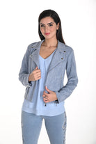 Woman wearing a gray studded jacket over a light blue top and jeans on a white background