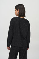 Back view of a woman wearing a Sequined Sweater Knit Top with a relaxed fit and subtle sparkle.