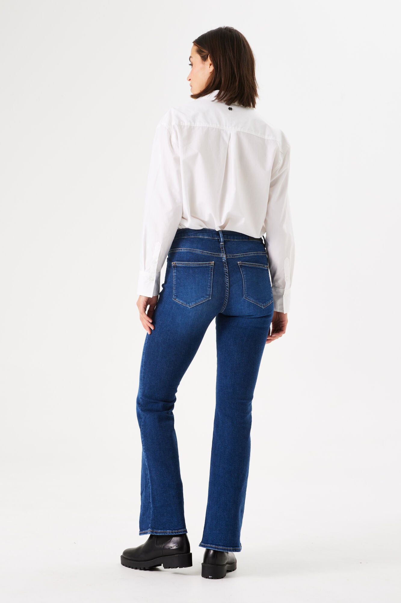 Back view of women's dark blue bootcut jeans featuring a mid-rise waist, classic five-pocket design, and subtle stretch denim.