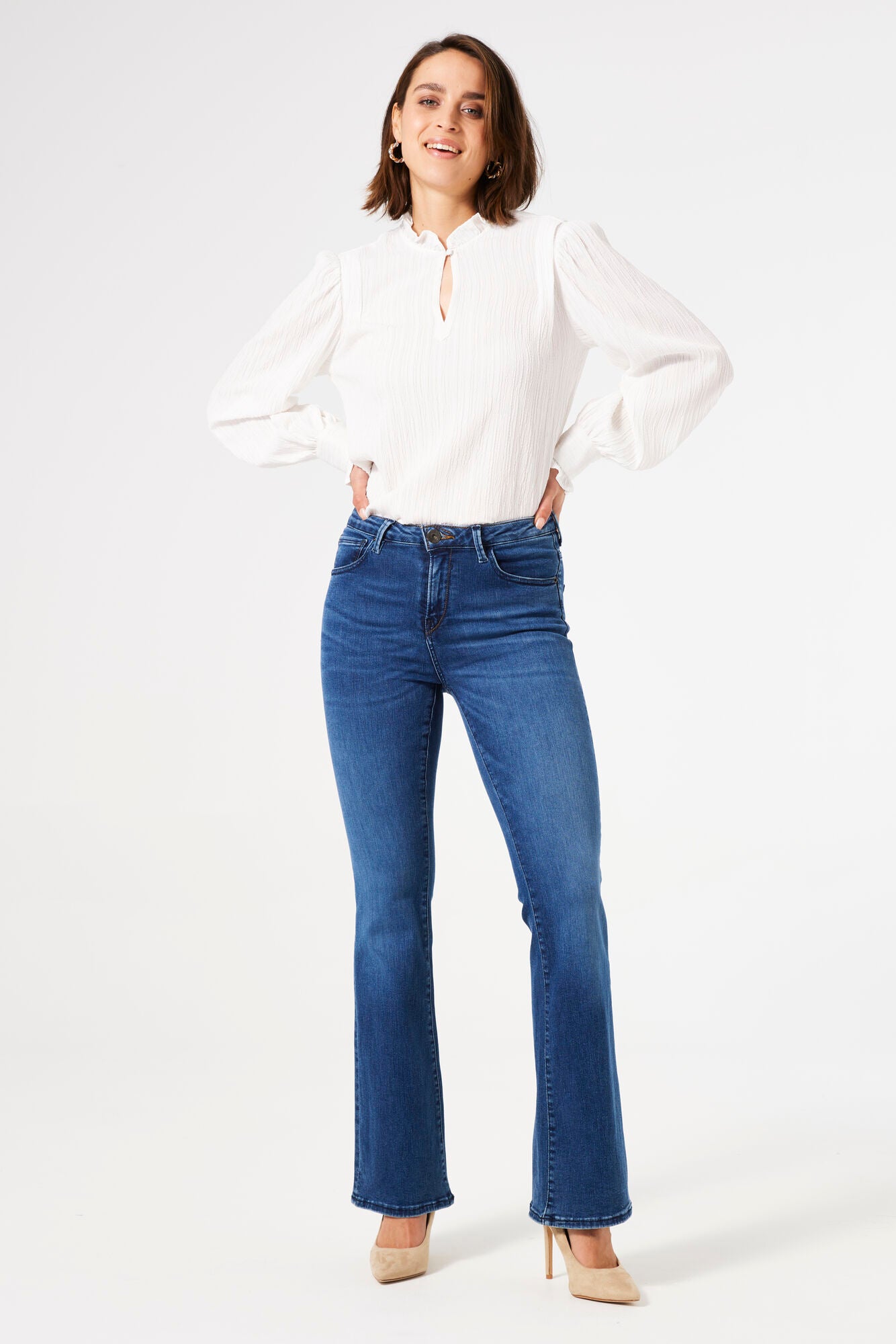 Women's mid-rise blue flare jeans with stretch denim, fitted through the hips and thighs with a flattering flared leg silhouette.