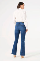 Back view of women's blue flare jeans featuring a mid-rise waist, classic back pockets, and a slim fit through the leg with a gentle flare.